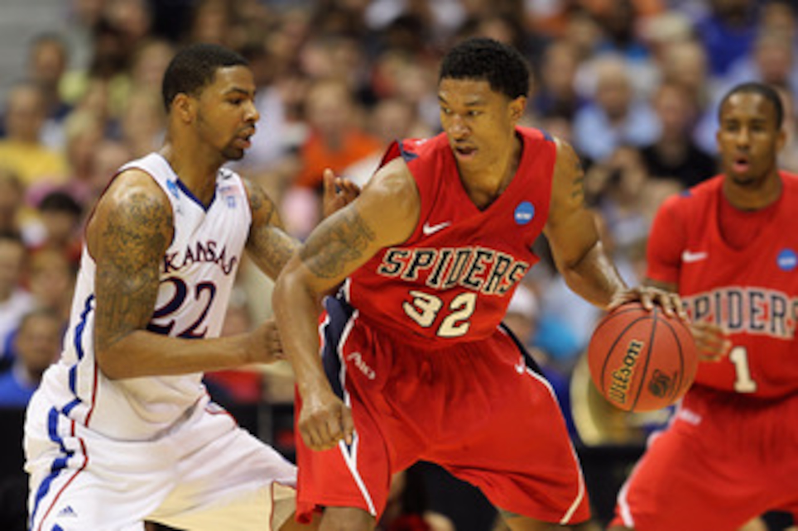 SAN ANTONIO, TX - MARCH 25:  Justin Harper #32 of the Richmond Spiders handles the ball against Marcus Morris #22 of the Kansas Jayhawks during the southwest regional of the 2011 NCAA men's basketball tournament at the Alamodome on March 25, 2011 in San A