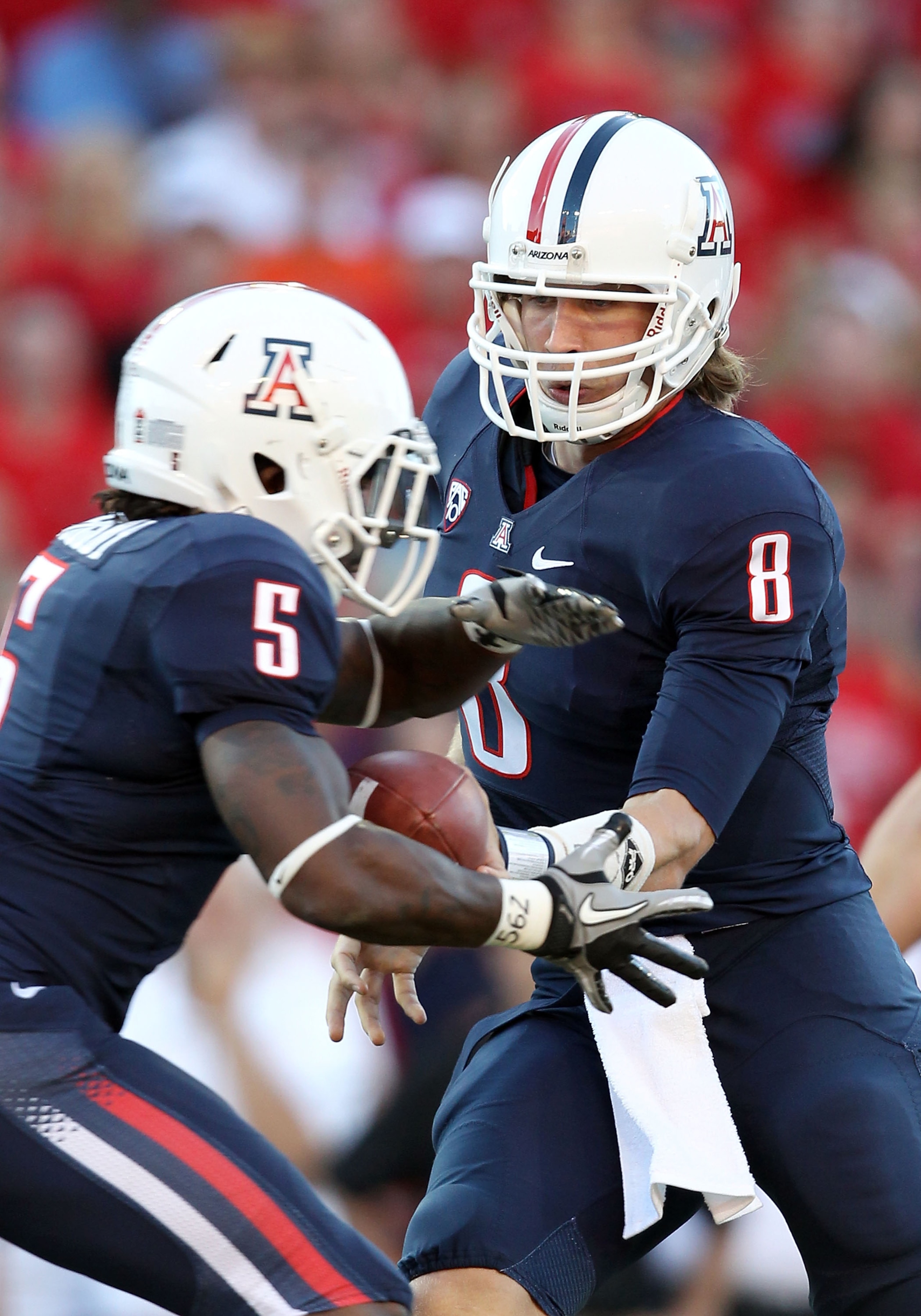 TUCSON, AZ - OCTOBER 09:  Quarterback Nick Foles #8 of the Arizona Wildcats hands off the ball to Nic Grigsby #5 during the college football game against the Oregon State Beavers at Arizona Stadium on October 9, 2010 in Tucson, Arizona.  (Photo by Christi