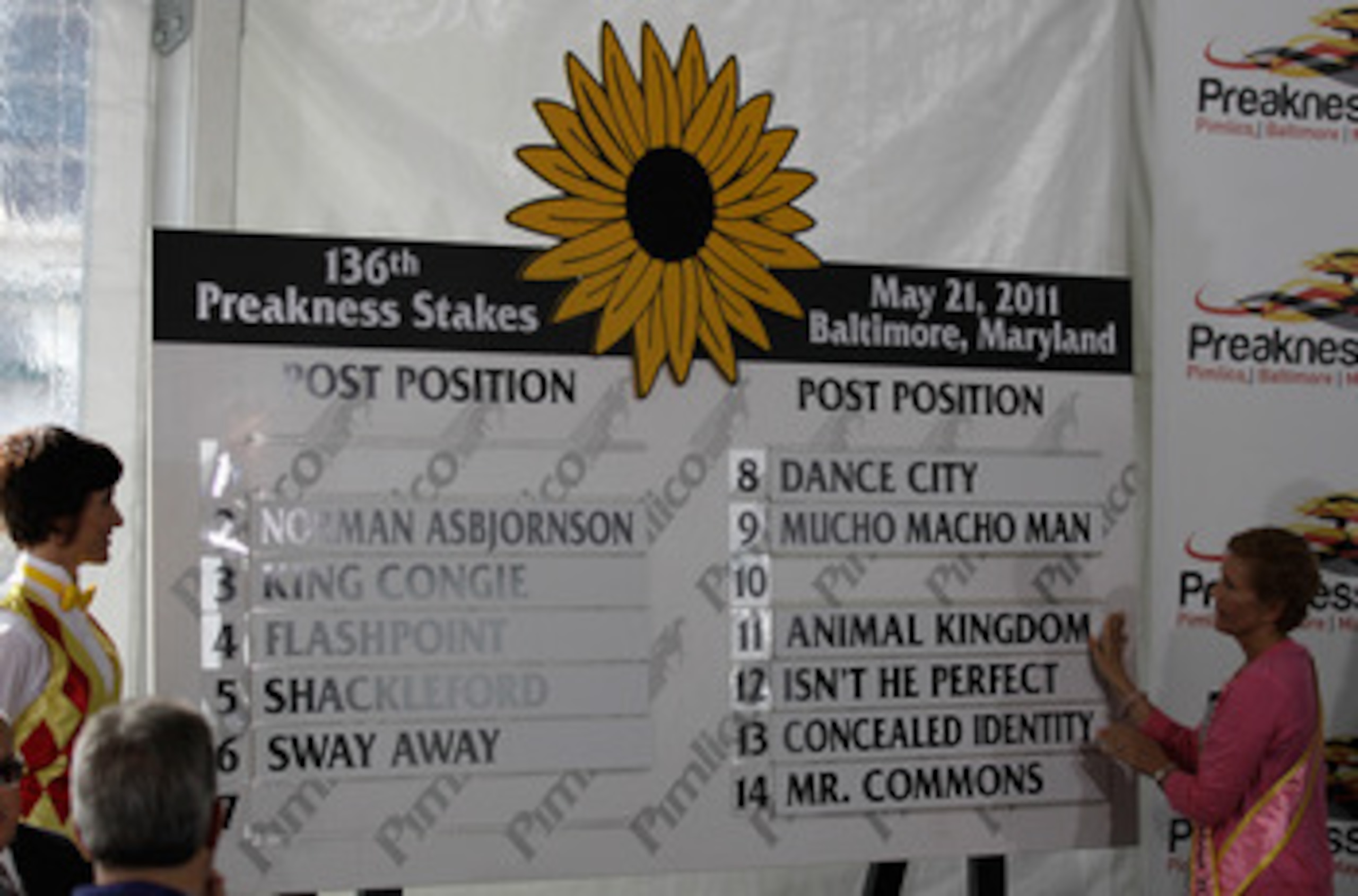BALTIMORE, MD - MAY 18: Susan Faber (R) places the name of Kentucky Derby winner and Preakness entrant Animal Kingdom on the board during the post position draw for the 136th running of the Preakness Stakes at  Pimlico Race Course on May 18, 2011 in Balti