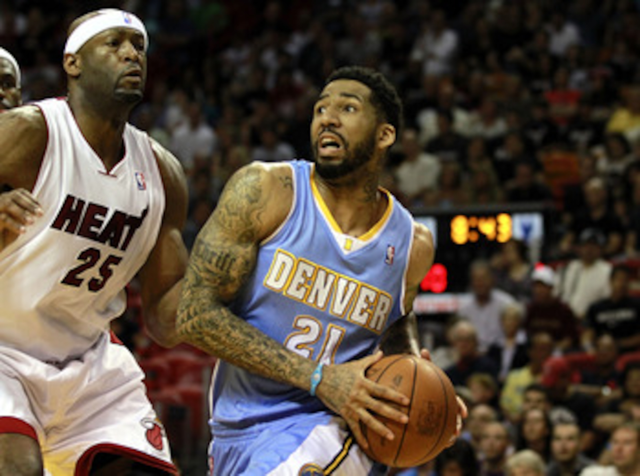 MIAMI, FL - MARCH 19:  Forward Wilson Chandler #21 of the Denver Nuggets drives against Center Erick Dampier #25 of the Miami Heat at American Airlines Arena on March 19, 2011 in Miami, Florida.  The Heat defeated the Nuggets 103-98. NOTE TO USER: User ex