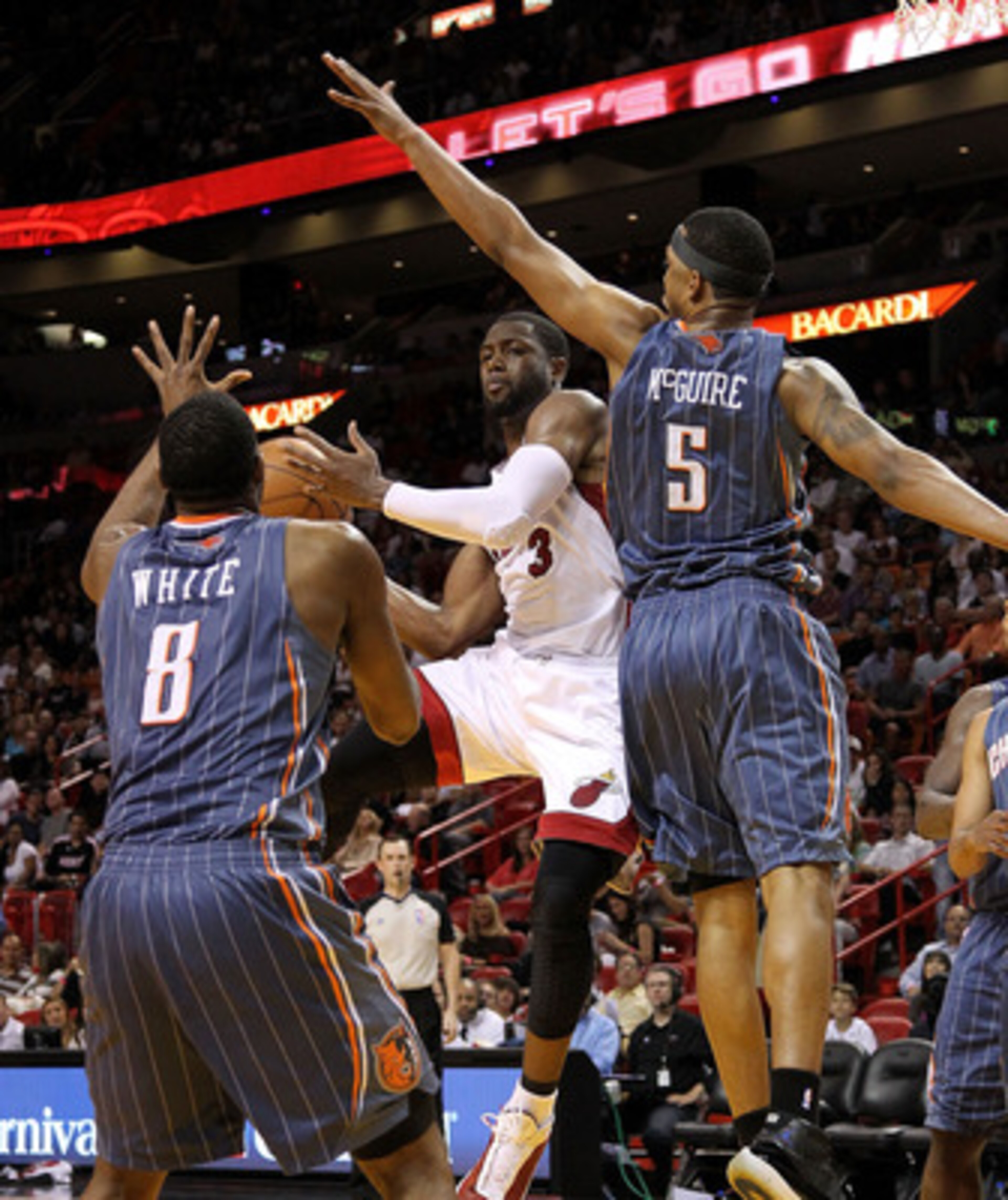 MIAMI, FL - APRIL 08:  Dwyane Wade #3 of the Miami Heat looks to pass away from D.J. White #8 and Dominic McGuire #5 of the Charlotte Bobcats during a game at American Airlines Arena on April 8, 2011 in Miami, Florida. NOTE TO USER: User expressly acknowl