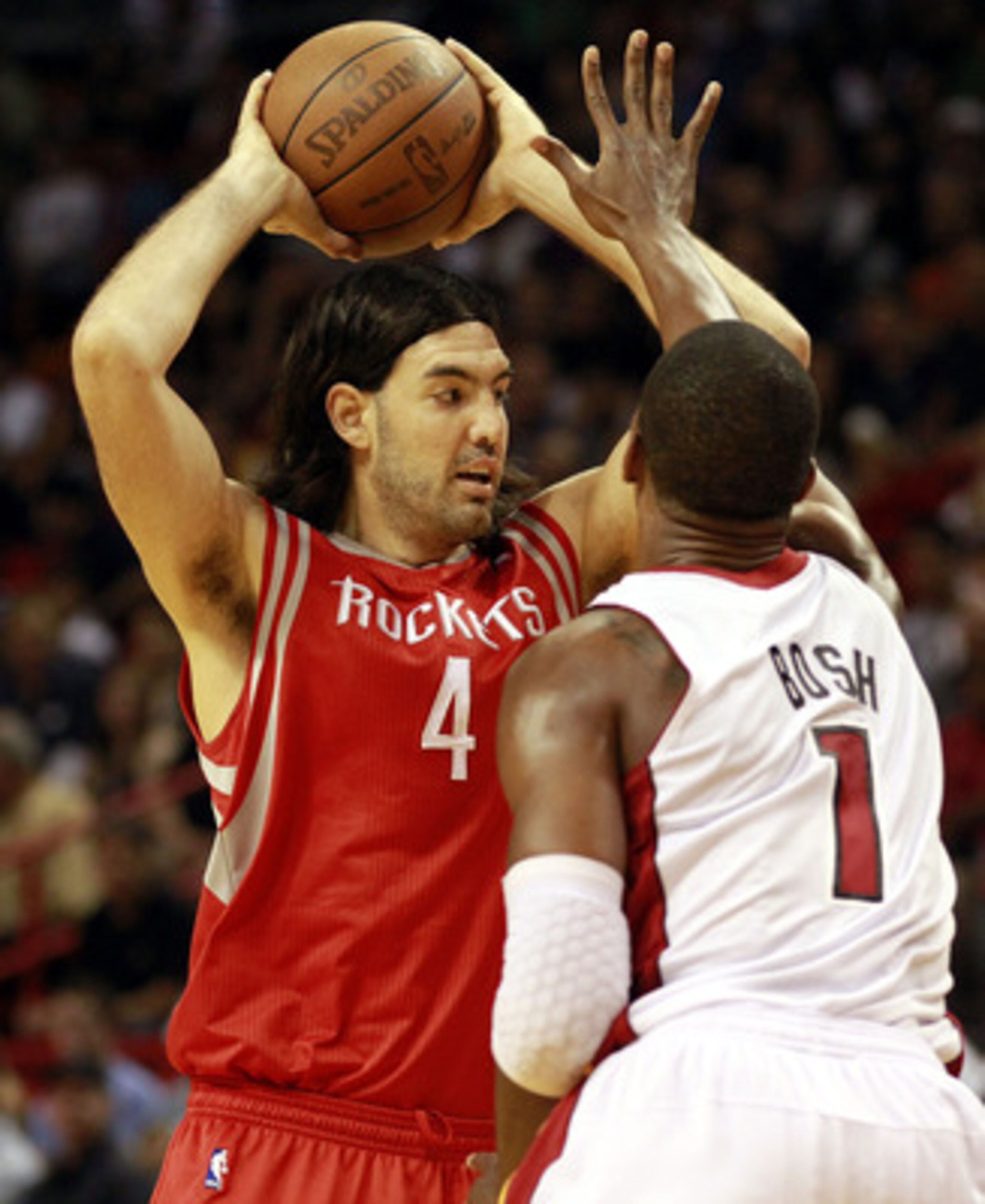 MIAMI, FL - MARCH 27:  Forward Chris Bosh #1 of the Miami Heat defends against Forward Luis Scola #4 of the Houston Rockets at American Airlines Arena on March 27, 2011 in Miami, Florida. NOTE TO USER: User expressly acknowledges and agrees that, by downl