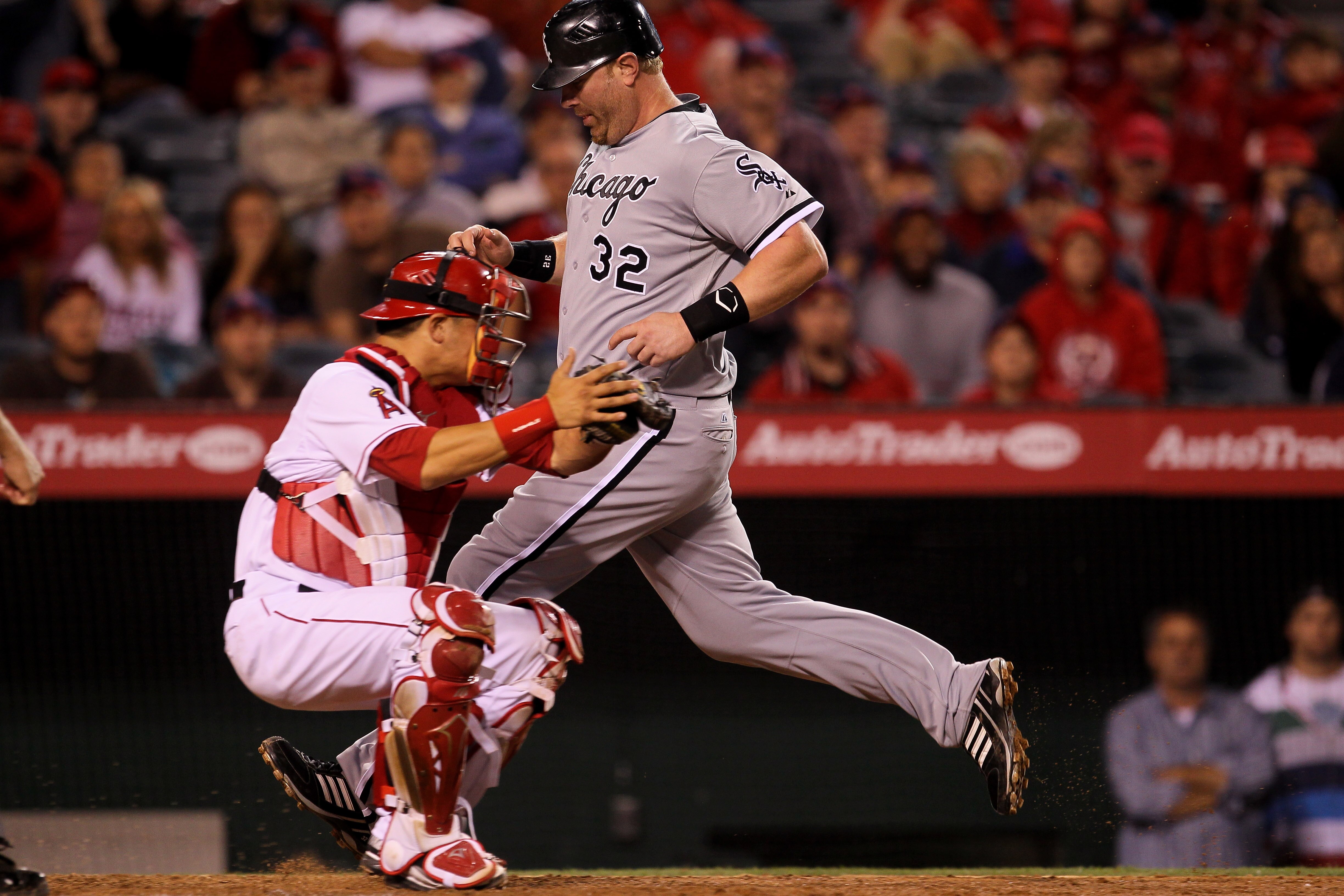 ANAHEIM, CA - MAY 11:  Adam Dunn #32 of the Chicago White Sox scores an insurance run in the tenth inning on a sacrifice fly ahead of the tag by catcher Hank Conger #16 of the Los Angeles Angels of Anaheim on May 11, 2011 at Angel Stadium in Anaheim, Cali