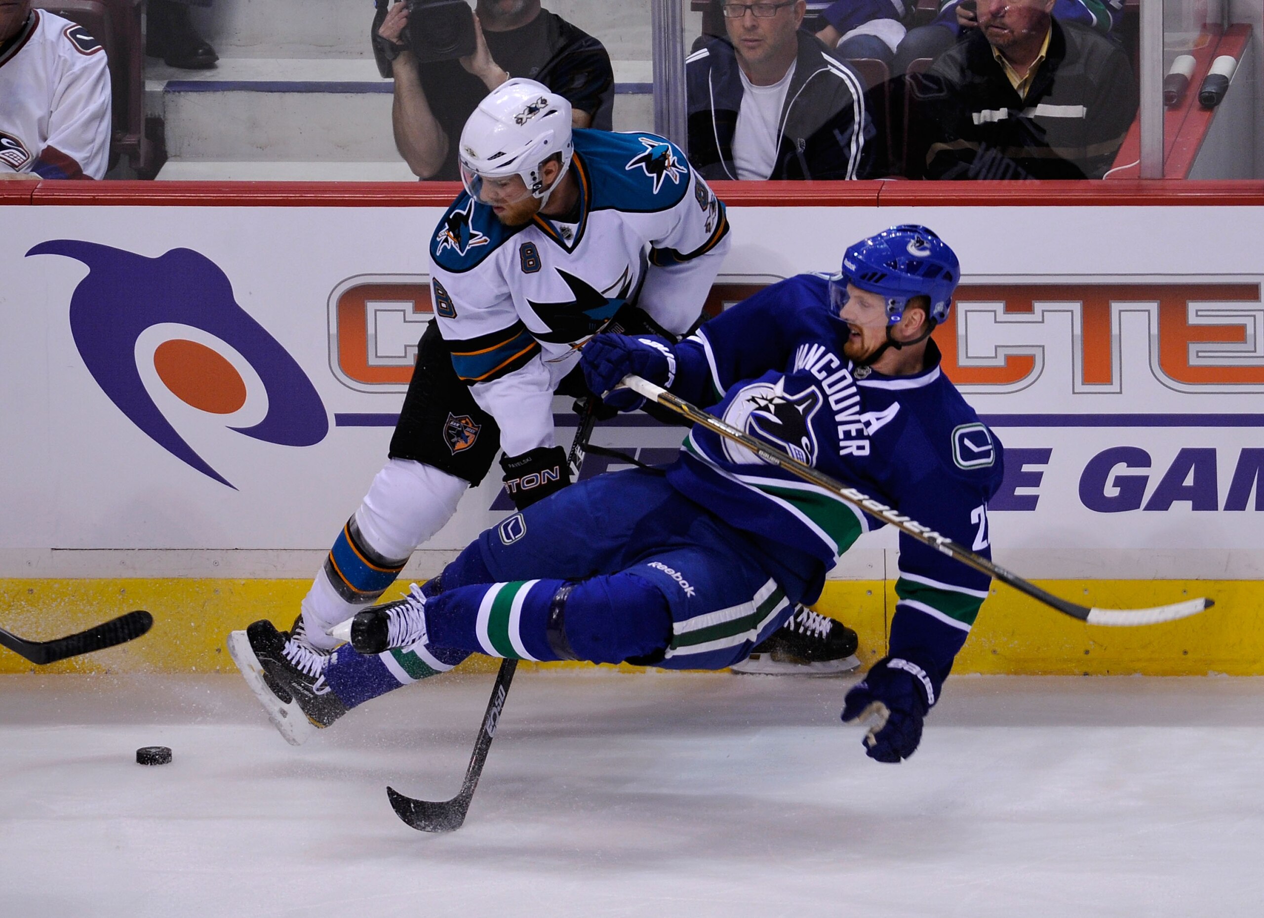 VANCOUVER, BC - MAY 18:  Joe Pavelski #8 of the San Jose Sharks trips up Daniel Sedin #22 of the Vancouver Canucks along the side boards during Game Two of the Western Conference Finals during the 2011 Stanley Cup Playoffs at Rogers Arena on May 18, 2011