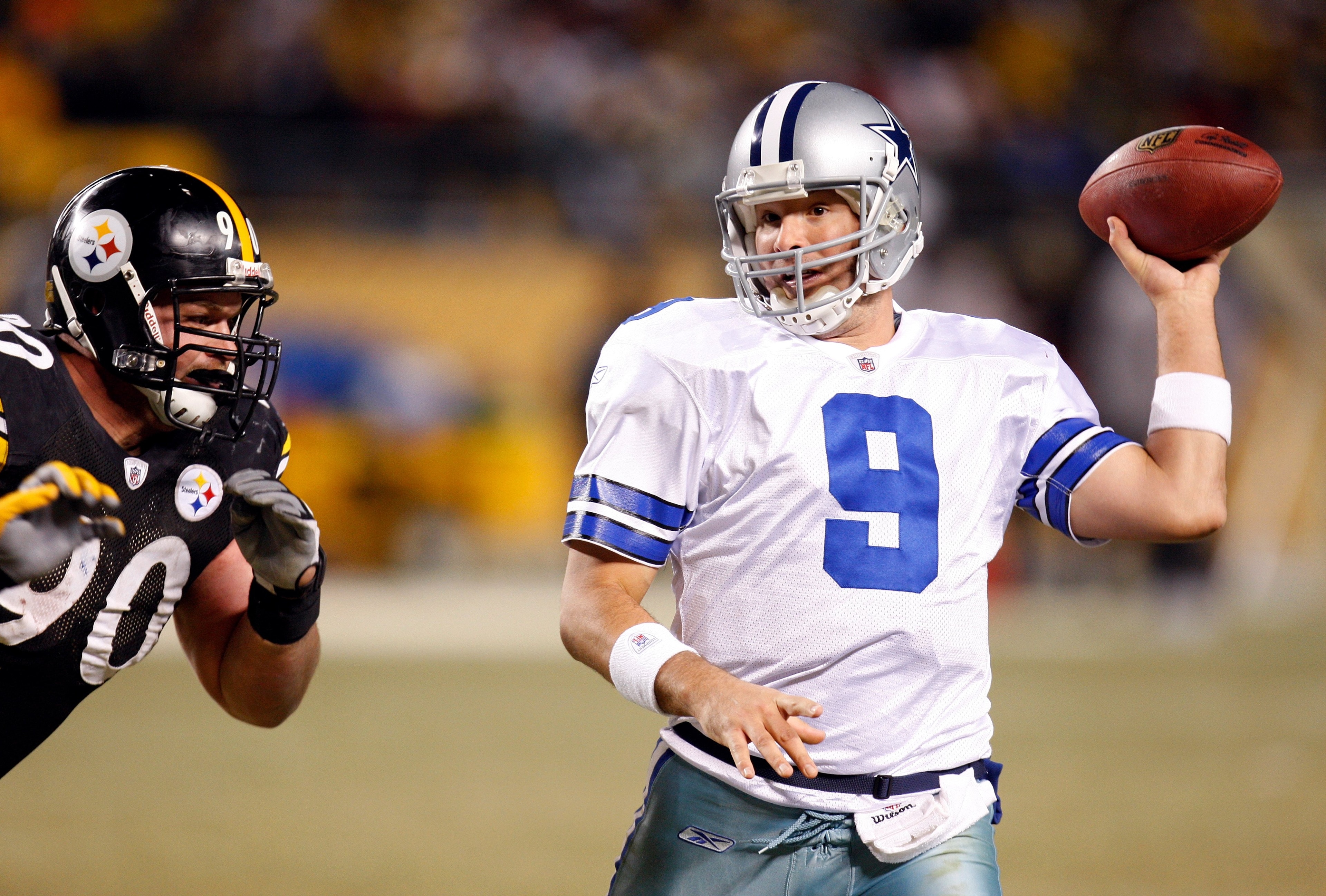 PITTSBURGH - DECEMBER 7:  Quarterback Tony Romo #9 of the Dallas Cowboys looks to pass the ball with his left hand while under pressure from Travis Kirschke #90 of the Pittsburgh Steelers during their NFL game on December 7, 2008 at Heinz Field in Pittsbu