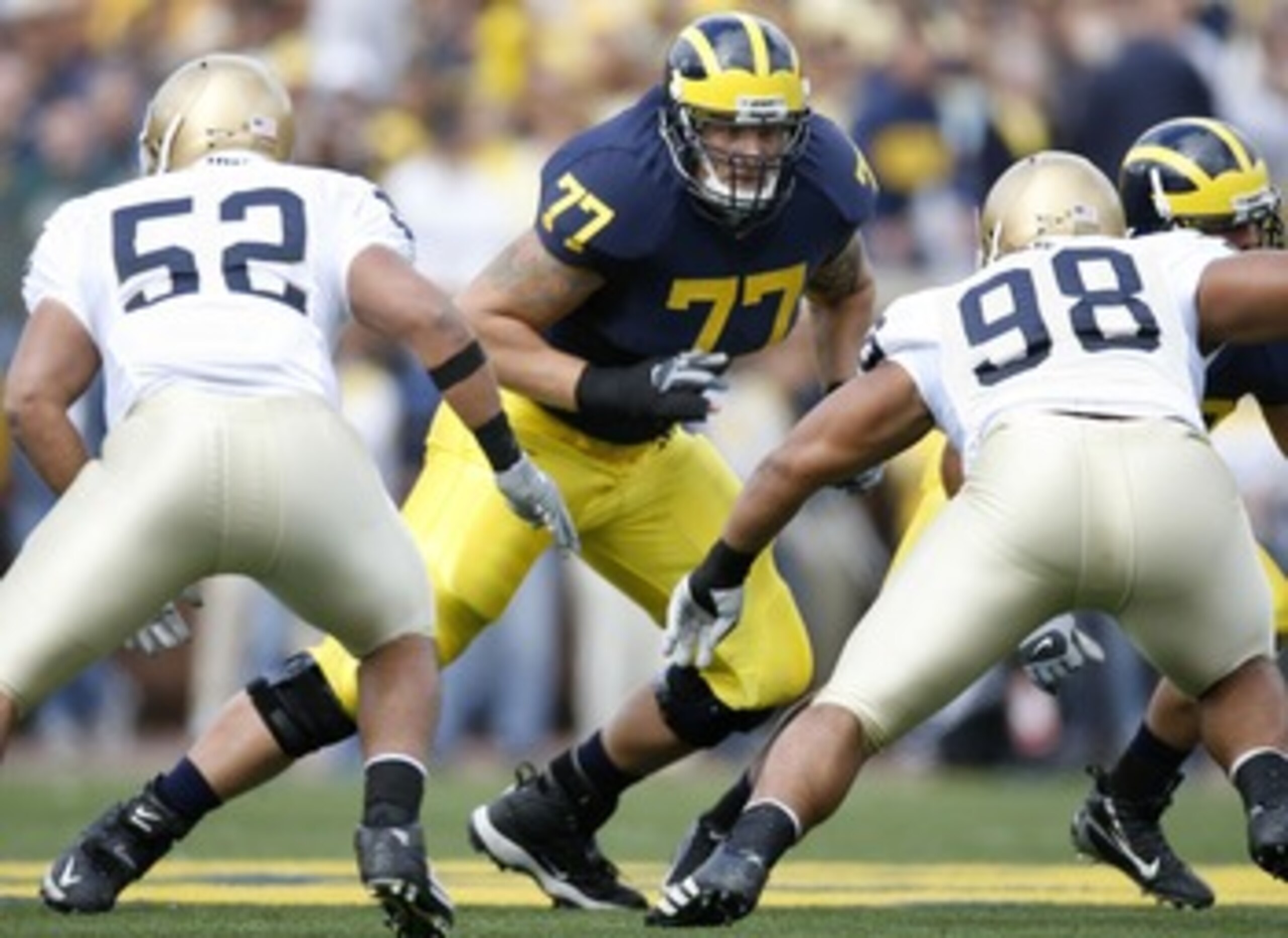 ANN ARBOR, MI - SEPTEMBER 15:  Jake Long #77 of the Michigan Wolverines gets ready to pass block against Joe Brockington #52 and Trevor Laws #98 of the Notre Dame Fighting Irish at Michigan Stadium September 15, 2007 in Ann Arbor, Michigan.  (Photo by Gre