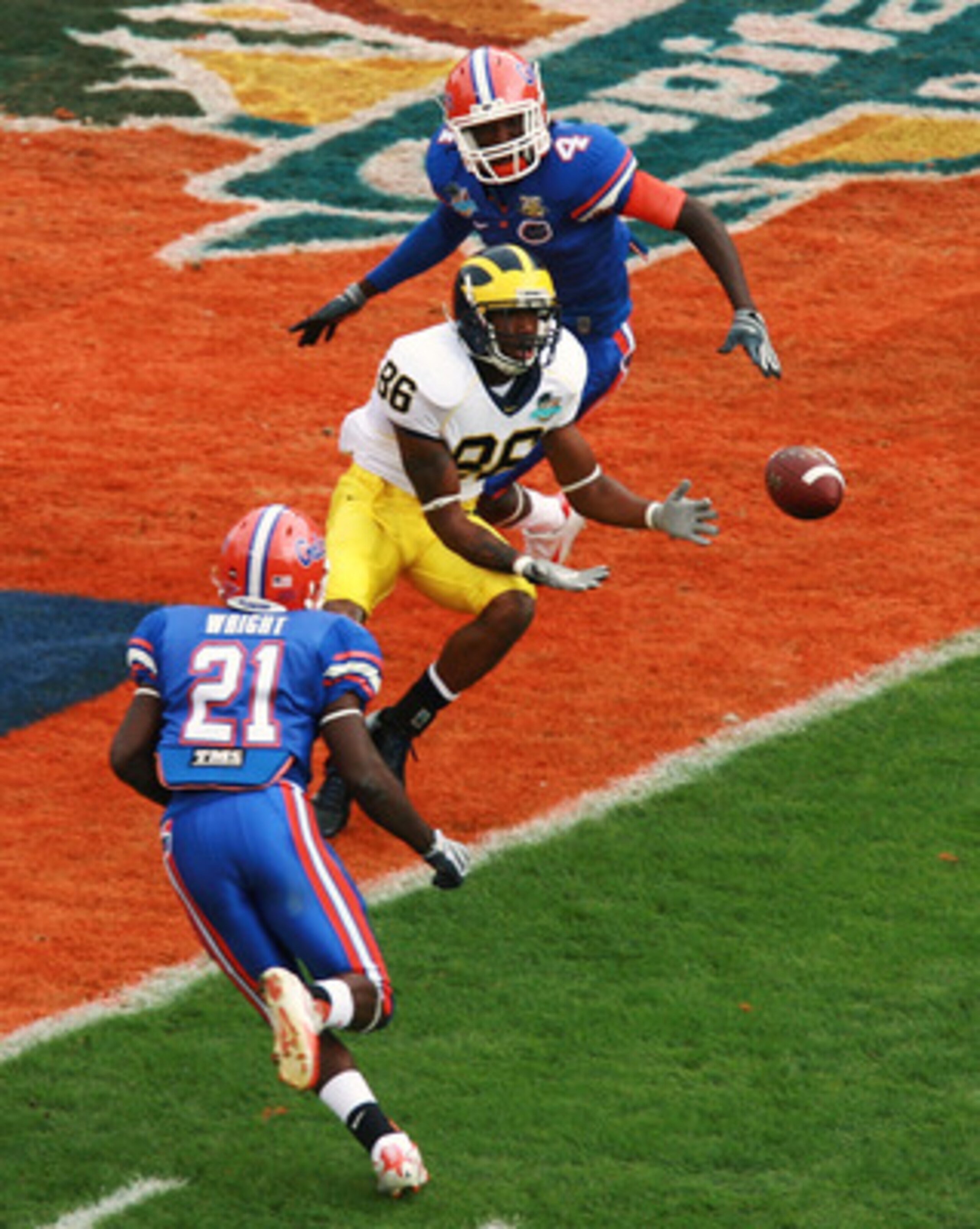 ORLANDO, FL - JANUARY 01:  Wide receiver Mario Manningham #86 of the Michigan Wolverines catches a touchdown pass between safety Major Wright #21 and cornerback Wondy Pierre-Louis #4 of the Florida Gators in the Capital One Bowl at Florida Citrus Bowl on