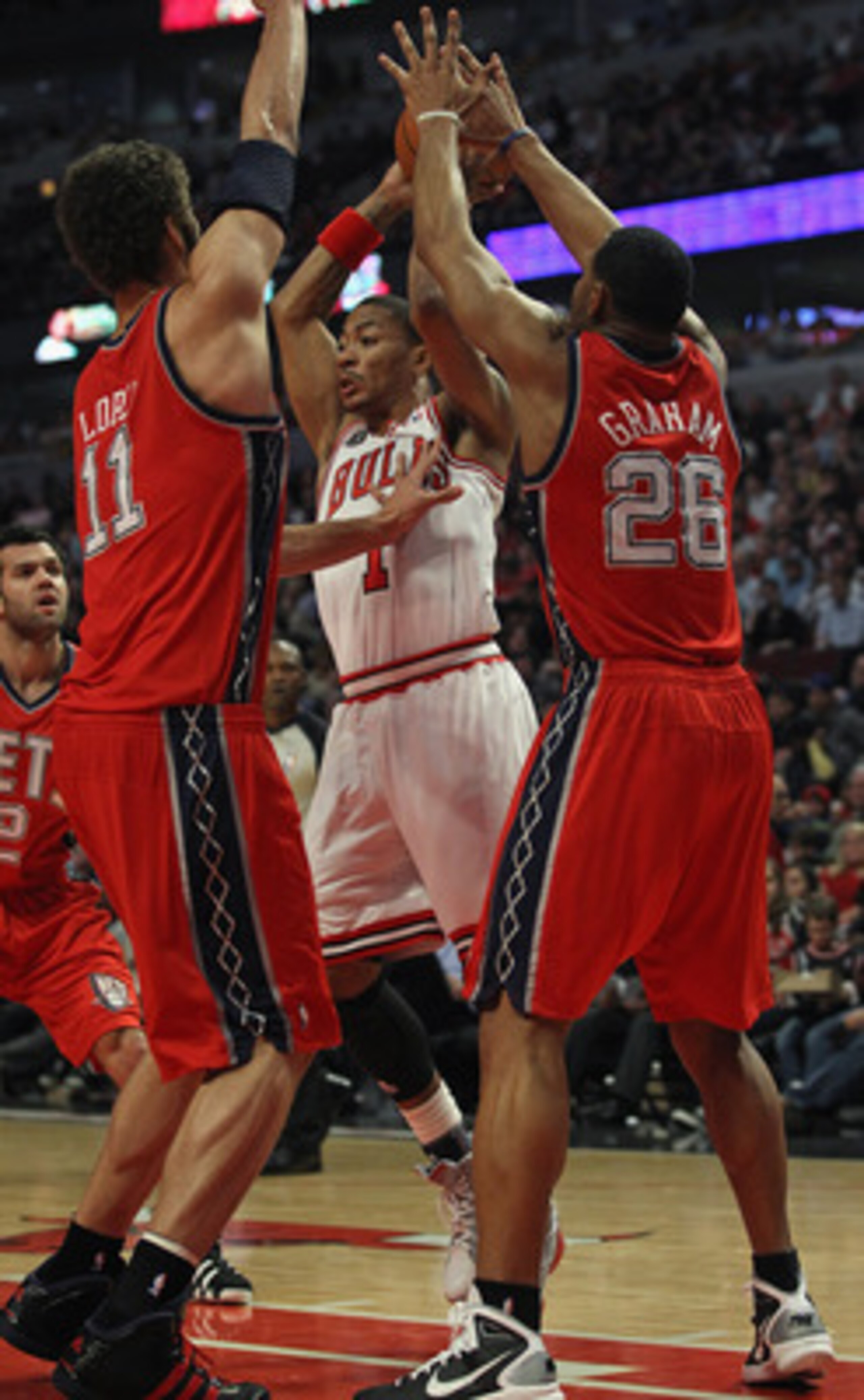 CHICAGO, IL - APRIL 13: Derrick Rose #1 of the Chicago Bulls looks to pass against Brook Lopez #11 and Stephen Graham #26 of the New Jersey Nets at the United Center on April 13, 2011 in Chicago, Illinois. The Bulls defeated the Nets 97-92. NOTE TO USER: CHICAGO, IL - APRIL 13: Derrick Rose #1 of the Chicago Bulls looks to pass against Brook Lopez #11 and Stephen Graham #26 of the New Jersey Nets at the United Center on April 13, 2011 in Chicago, Illinois. The Bulls defeated the Nets 97-92. NOTE TO USER: