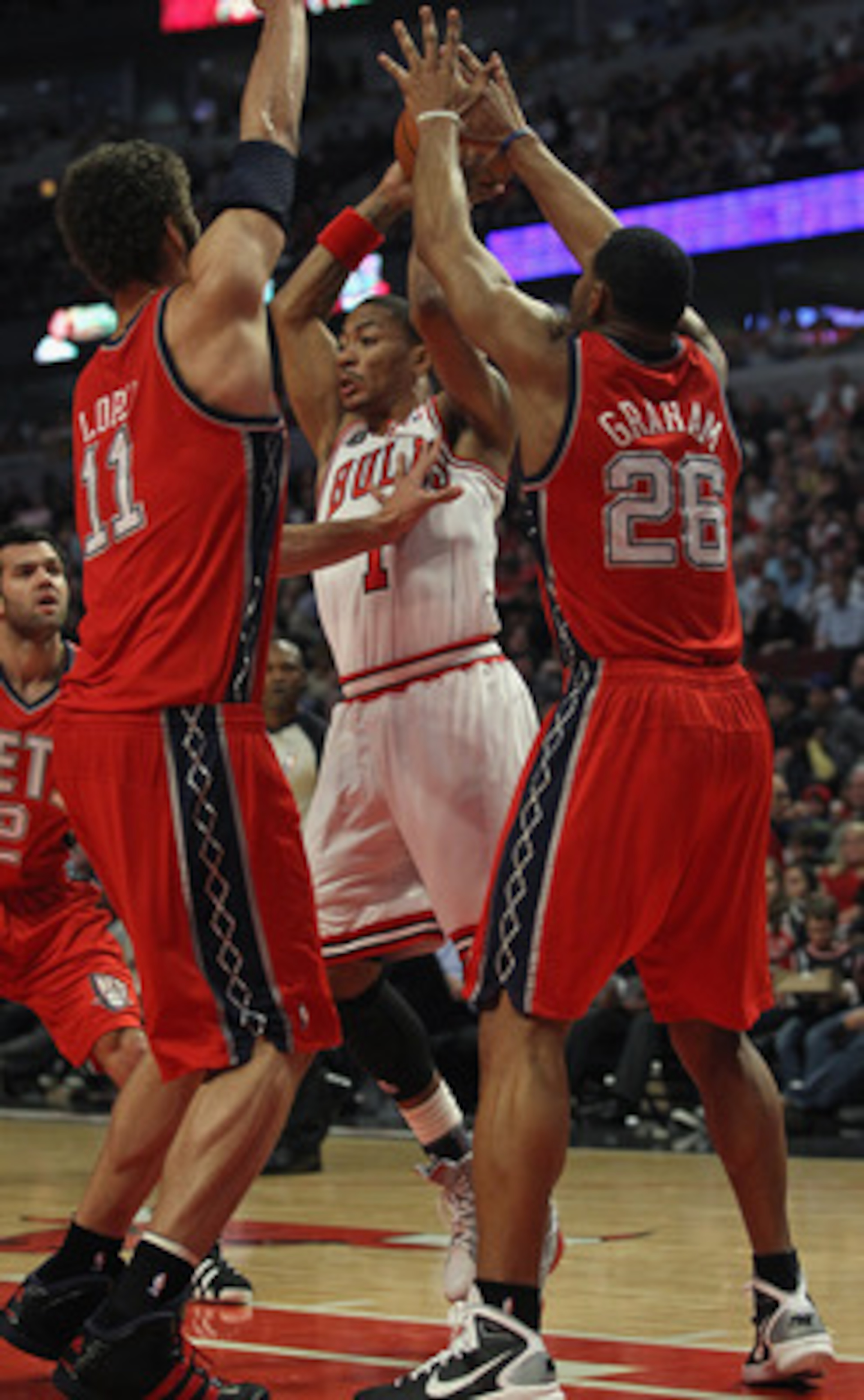 CHICAGO, IL - APRIL 13: Derrick Rose #1 of the Chicago Bulls looks to pass against Brook Lopez #11 and Stephen Graham #26 of the New Jersey Nets at the United Center on April 13, 2011 in Chicago, Illinois. The Bulls defeated the Nets 97-92. NOTE TO USER: