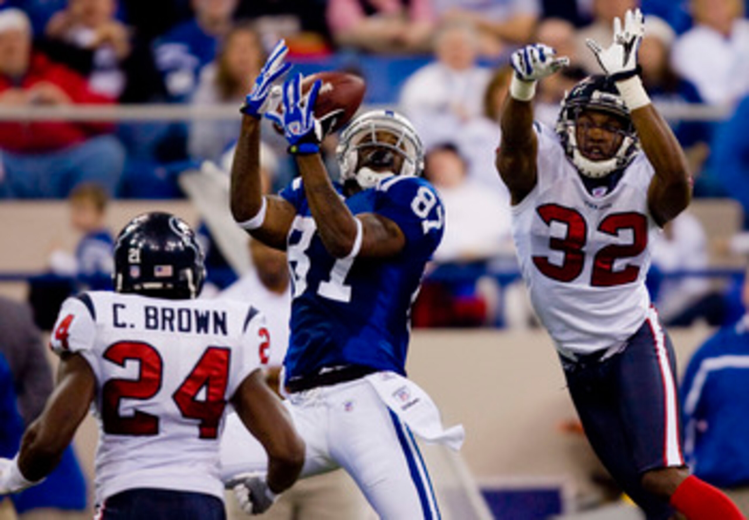 INDIANAPOLIS, IN - DECEMBER 23: Reggie Wayne #87 of the Indianapolis Colts attempts to haul in a pass against C.C. Brown #24 and Fred Bennett #32 both of the Houston Texans on December 23, 2007 at the RCA Dome in Indianapolis, Indiana.  The Colts beat the