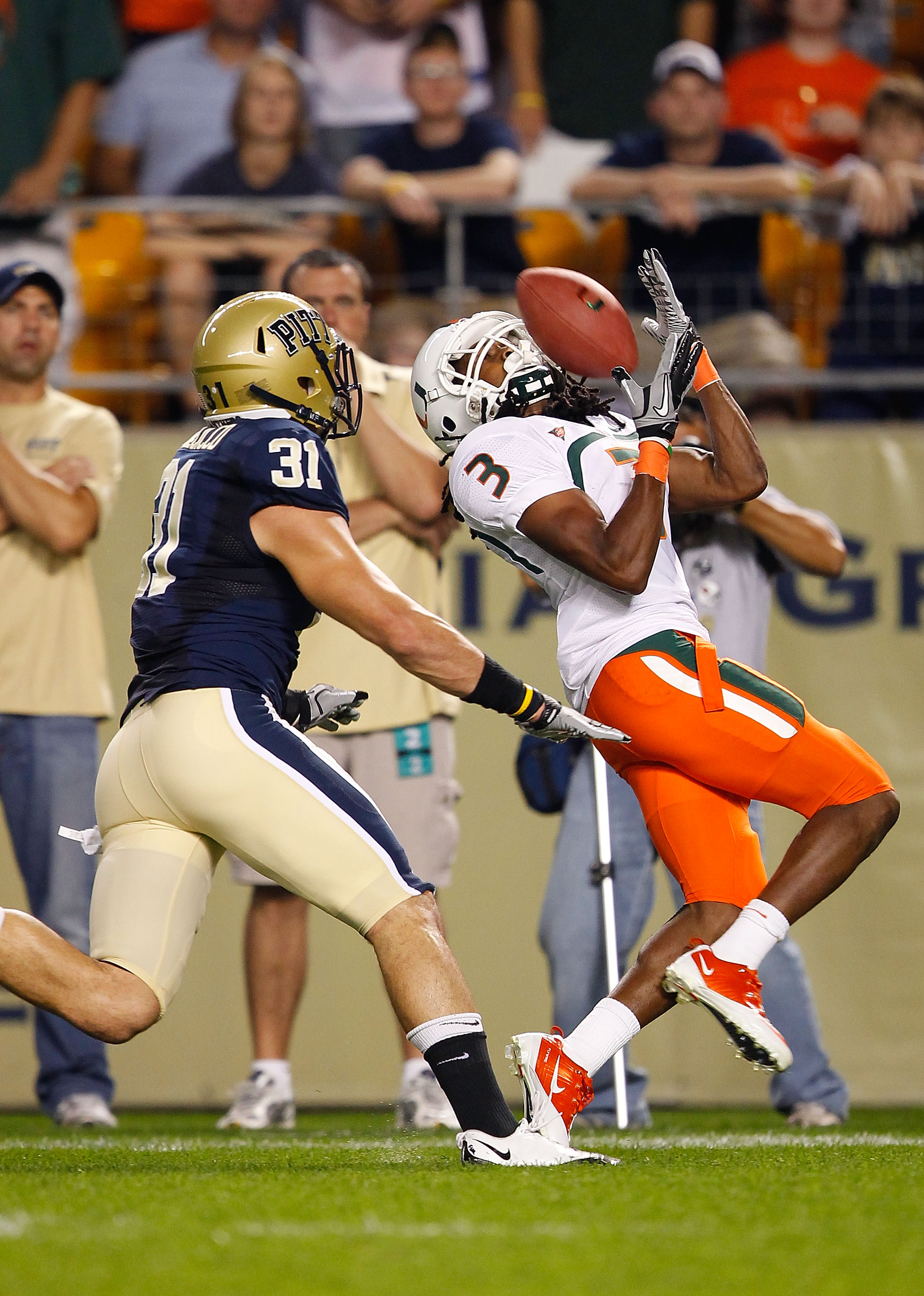 PITTSBURGH - SEPTEMBER 23:  Travis Benjamin #3 of the Miami Hurricanes catches a pass in front of Dom Decicco #31 of the Pittsburgh Panthers on September 23, 2010 at Heinz Field in Pittsburgh, Pennsylvania.  (Photo by Jared Wickerham/Getty Images)