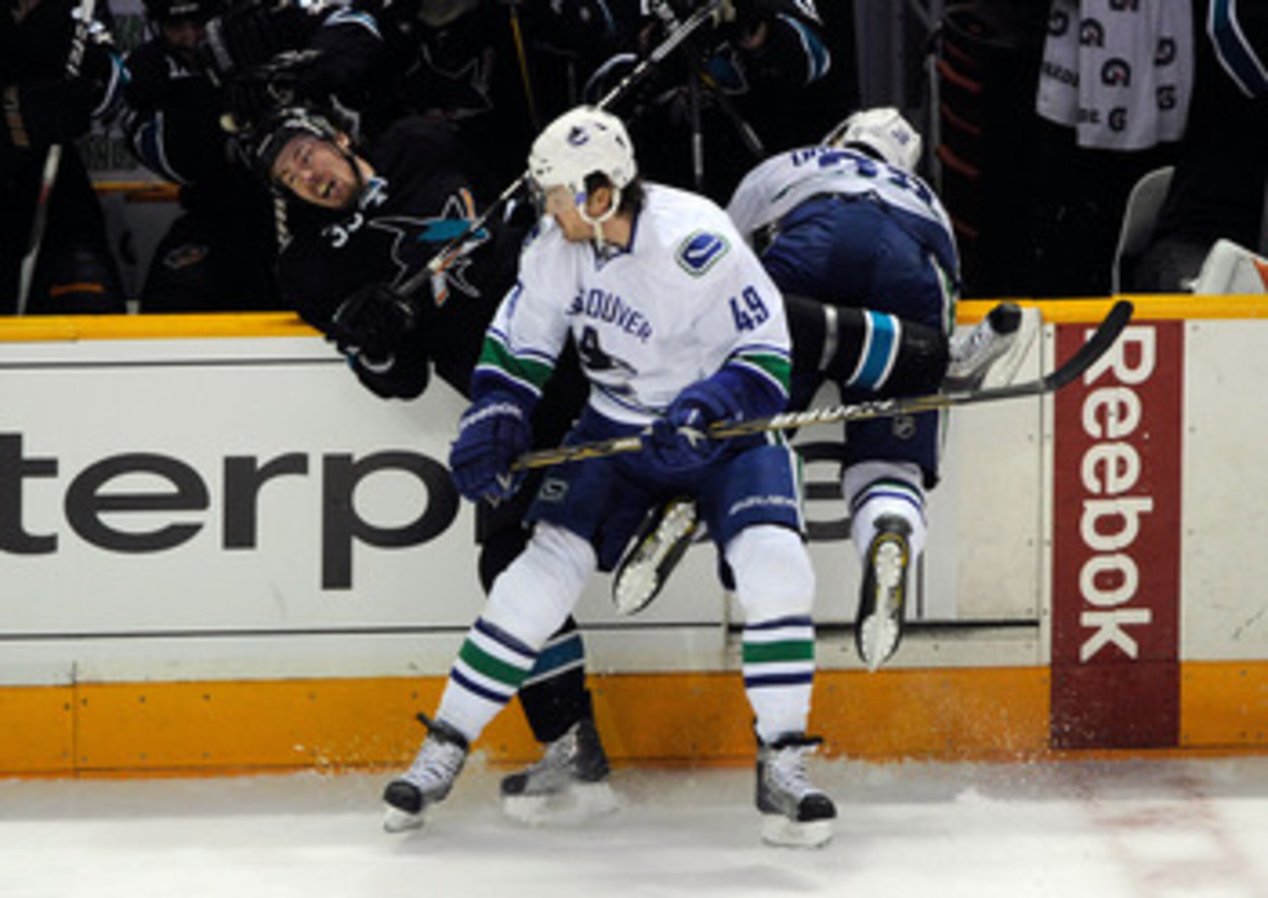 SAN JOSE, CA - MAY 20:  Alexandre Bolduc #49 of the Vancouver Canucks checks Logan Couture #39 of the San Jose Sharks near the bench area in the first period in Game Three of the Western Conference Finals during the 2011 Stanley Cup Playoffs at HP Pavilio