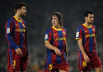 BARCELONA, SPAIN - JANUARY 16:  Gerard Pique (L), Carles Puyol (C) and Sergio Busquets of FC Barcelona look on during the La Liga match between FC Barcelona and Malaga at Nou Camp on January 16, 2011 in Barcelona, Spain. Barcelona won 4-1.  (Photo by Davi