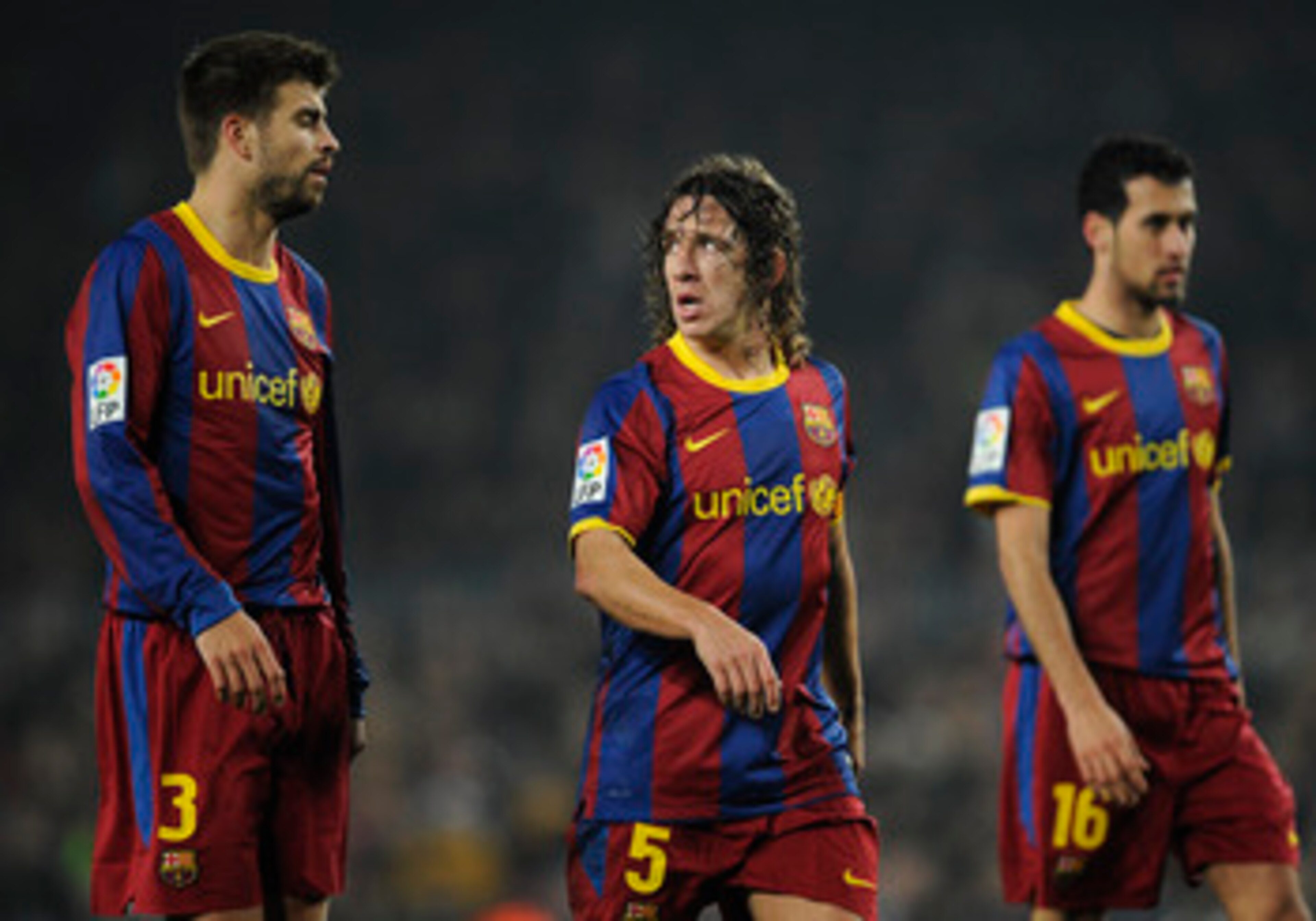 BARCELONA, SPAIN - JANUARY 16:  Gerard Pique (L), Carles Puyol (C) and Sergio Busquets of FC Barcelona look on during the La Liga match between FC Barcelona and Malaga at Nou Camp on January 16, 2011 in Barcelona, Spain. Barcelona won 4-1.  (Photo by Davi