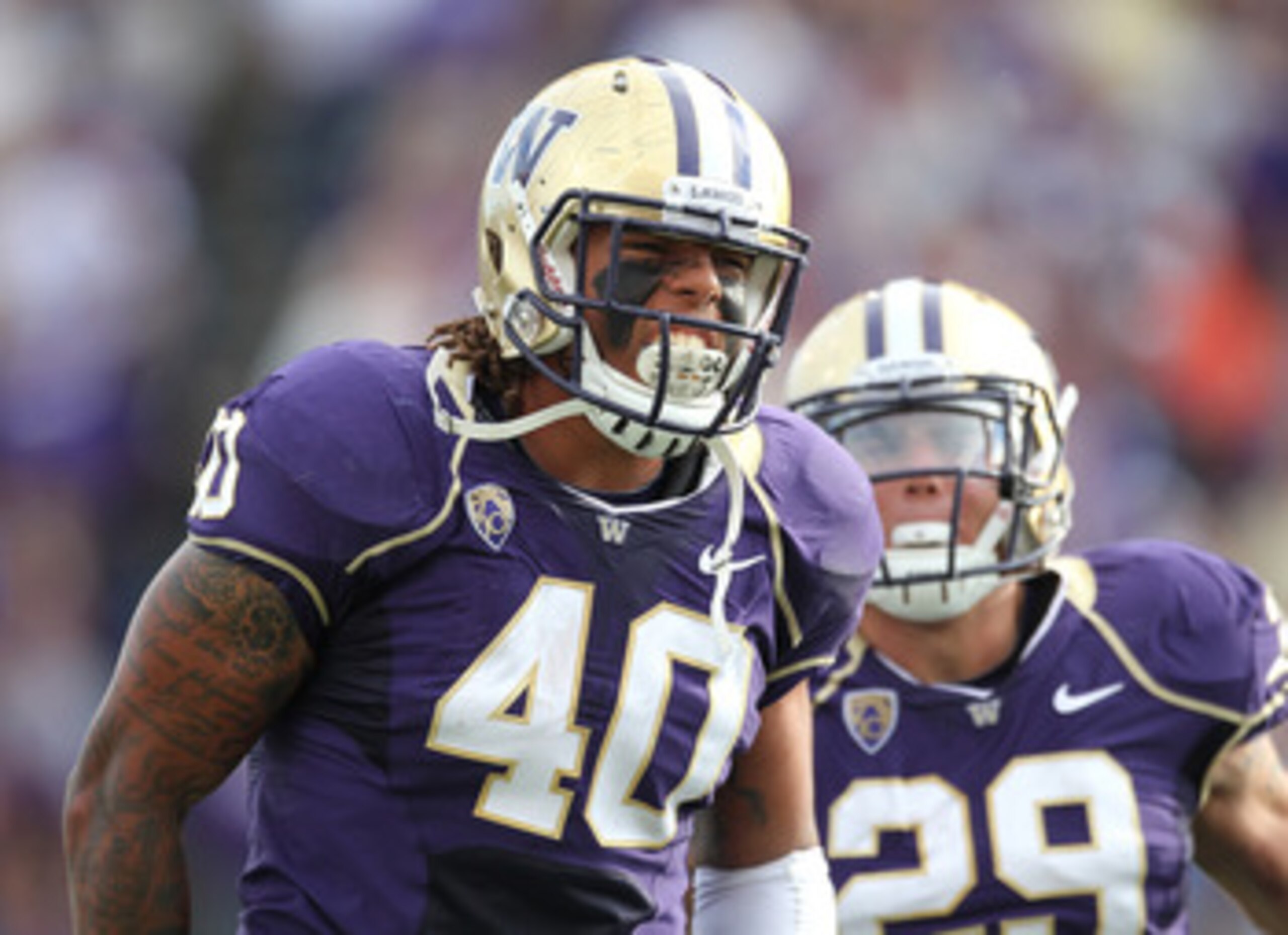 SEATTLE - SEPTEMBER 11:  Linebacker Mason Foster #40 of the Washington Huskies celebrates with Willis Wilson #29 after tackling quarterback Ryan Nassib #12 of the Syracuse Orange and causing a fumble on September 11, 2010 at Husky Stadium in Seattle, Wash