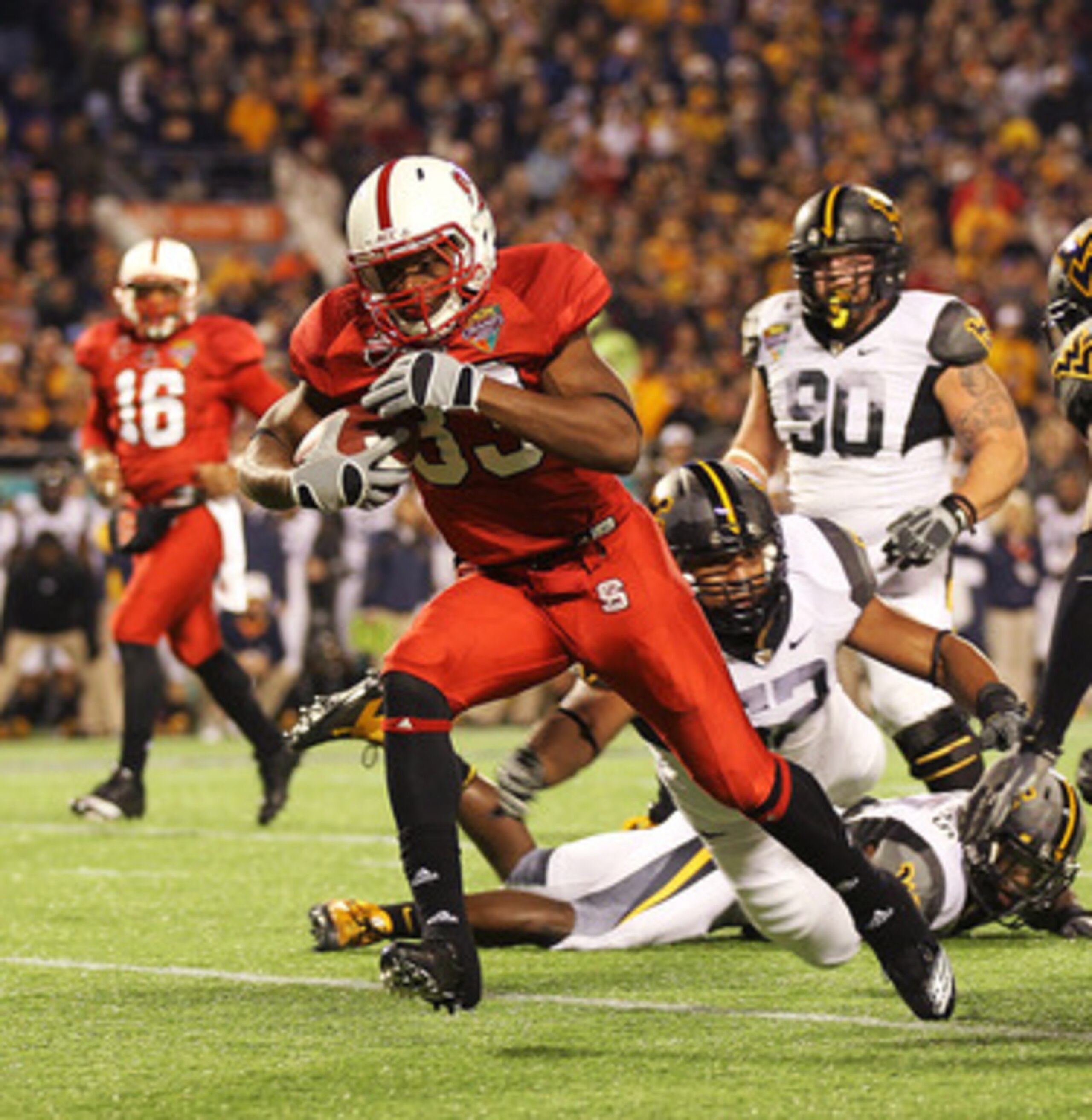 ORLANDO, FL - DECEMBER 28: Mustafa Greene #33 of the North Carolina State Wolfpack scores a touchdown during the Champs Sports Bowl against the West Virginia Mountineers at Florida Citrus Bowl Stadium on December 28, 2010 in Orlando, Florida. (Photo by ORLANDO, FL - DECEMBER 28: Mustafa Greene #33 of the North Carolina State Wolfpack scores a touchdown during the Champs Sports Bowl against the West Virginia Mountineers at Florida Citrus Bowl Stadium on December 28, 2010 in Orlando, Florida. (Photo by