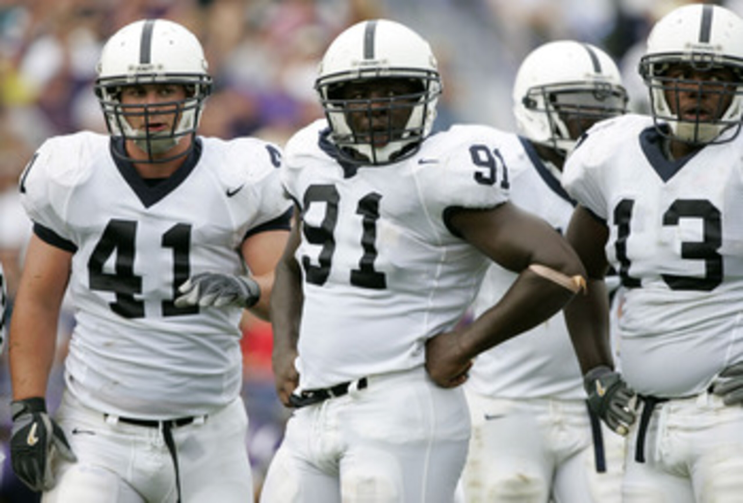 EVANSTON, IL - SEPTEMBER 24:  (L-R) Defensive tackle Scott Paxson #41, defensive end Tamba Hali #93 and defensive tackle Jay Alford #13 of the Penn State Nittany Lions wait for their defensive assignment from the coaches against the Northwestern Wildcats