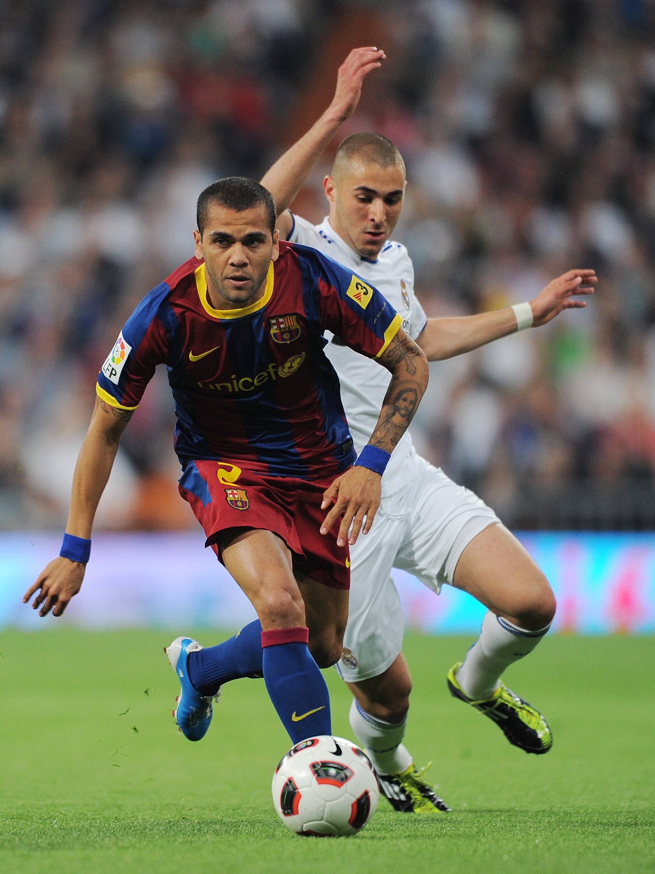 MADRID, SPAIN - APRIL 16:  Daniel Alves (L) of Barcelona duels for the ball with Karim Benzema of Real Madrid during the la Liga match between Real Madrid and Barcelona at Estadio Santiago Bernabeu on April 16, 2011 in Madrid, Spain.  (Photo by Jasper Jui