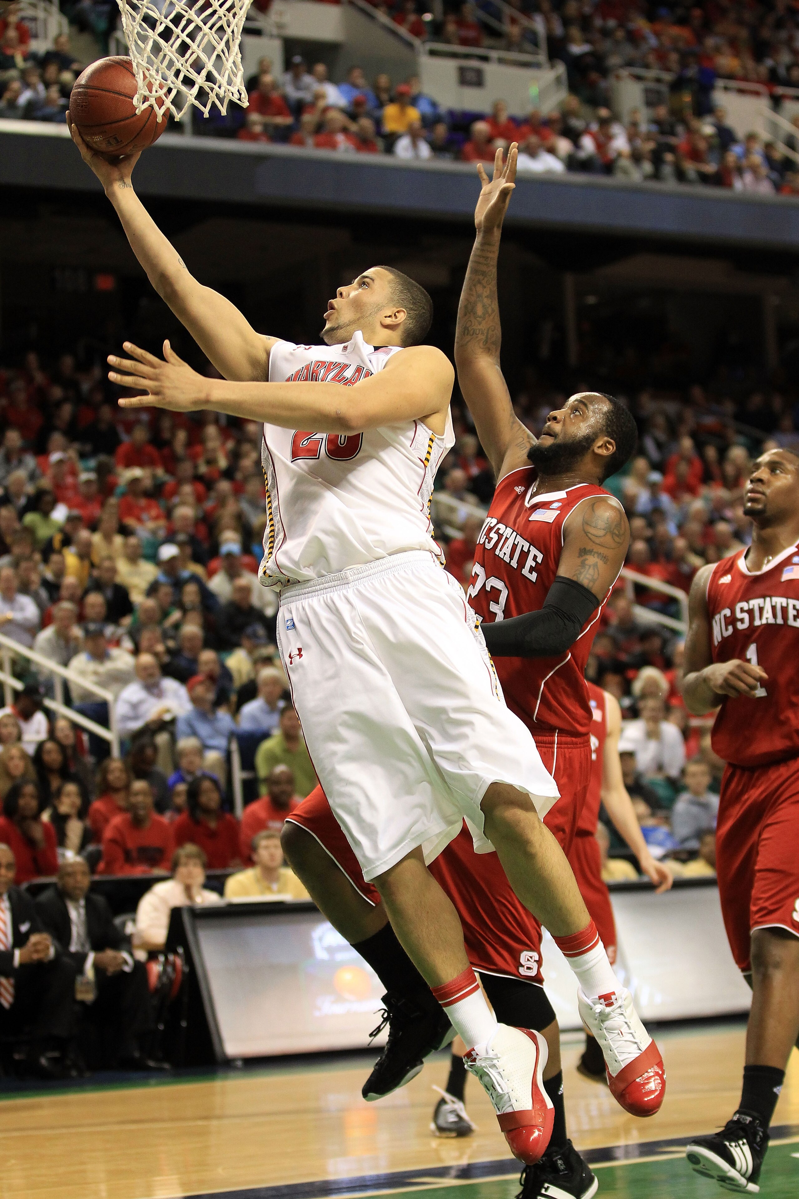 GREENSBORO, NC - MARCH 10:  Jordan Williams #20 of the Maryland Terrapins shoots against Tracy Smith #23 of the North Carolina State Wolfpack during the first half of the game in the first round of the 2011 ACC men's basketball tournament at the Greensbor