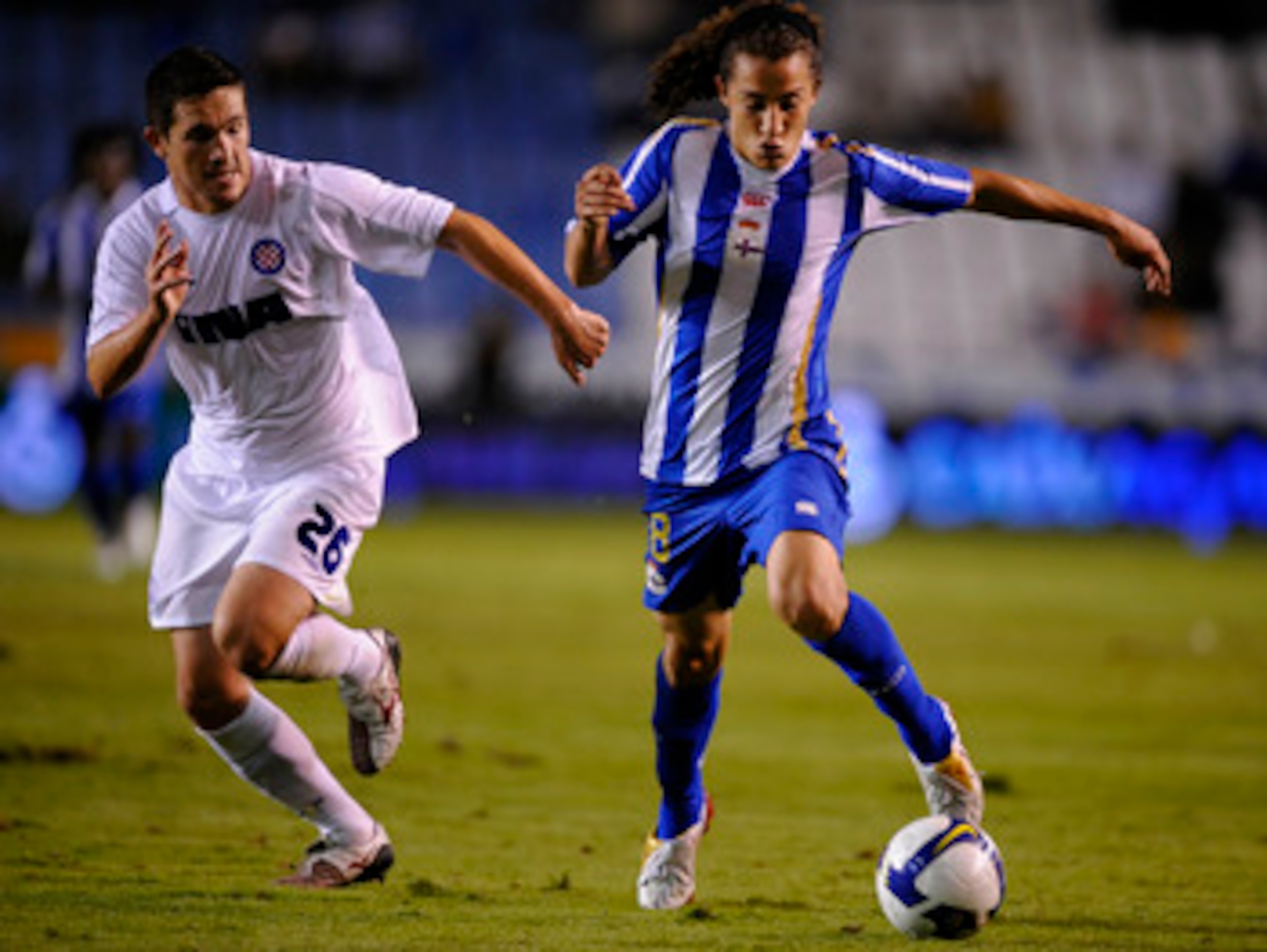 A CORUNA, SPAIN - AUGUST 14: Andres Guardado (R) of Deportivo La Coruna gets past Goran Rubil of Hadjuk Split during the UEFA Cup Second Qualifying Round, first leg match between Deportivo La Coruna and Hadjuk Split at the Riazor stadium on August 14, 200