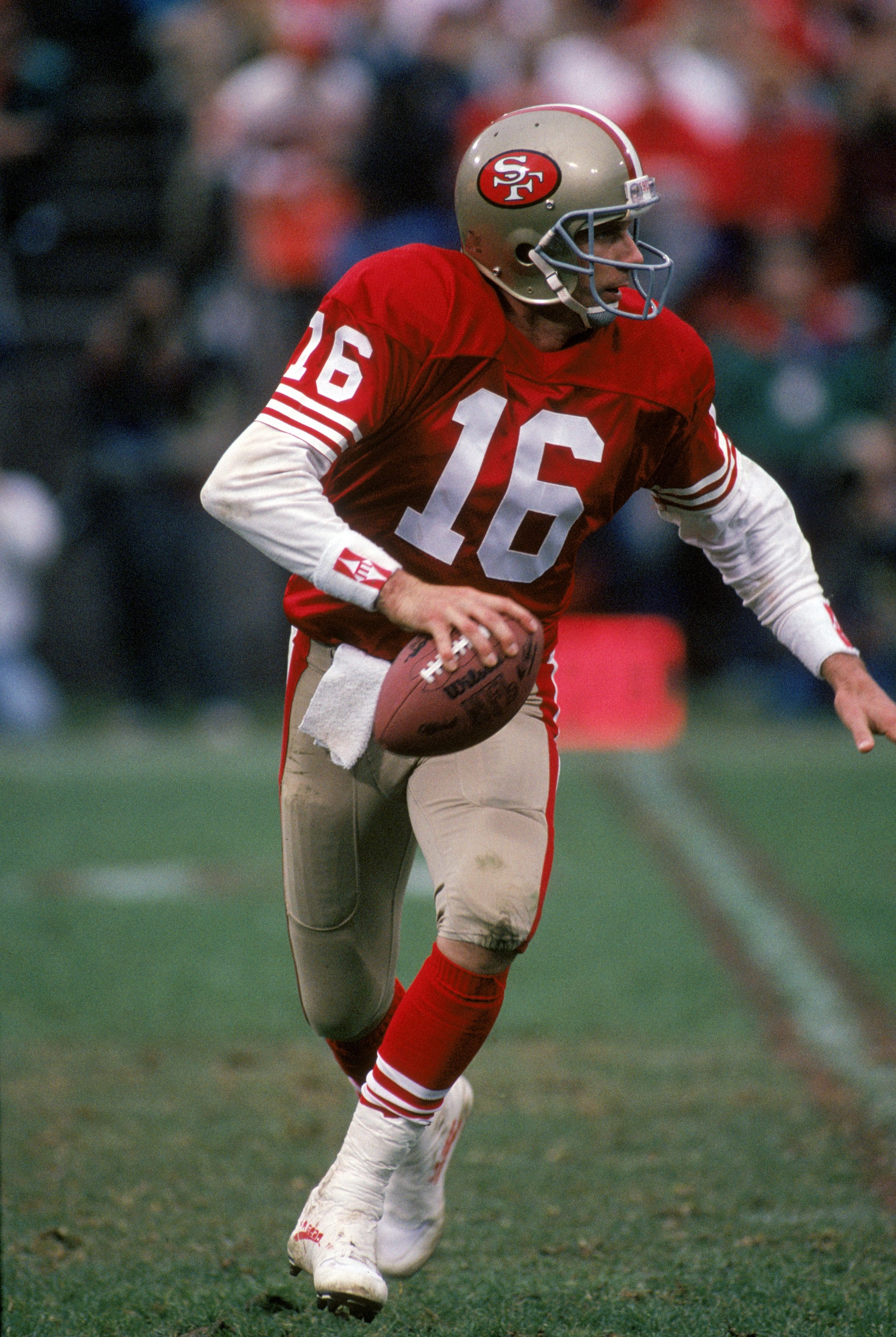 SAN FRANCISCO - JANUARY 12:  Quarterback Joe Montana #16 of the San Francisco 49ers runs with the ball as he looks down field for a receiver during the 1990 NFC Divisional Playoff game against the Washington Redskins at Candlestick Park on January 12, 199