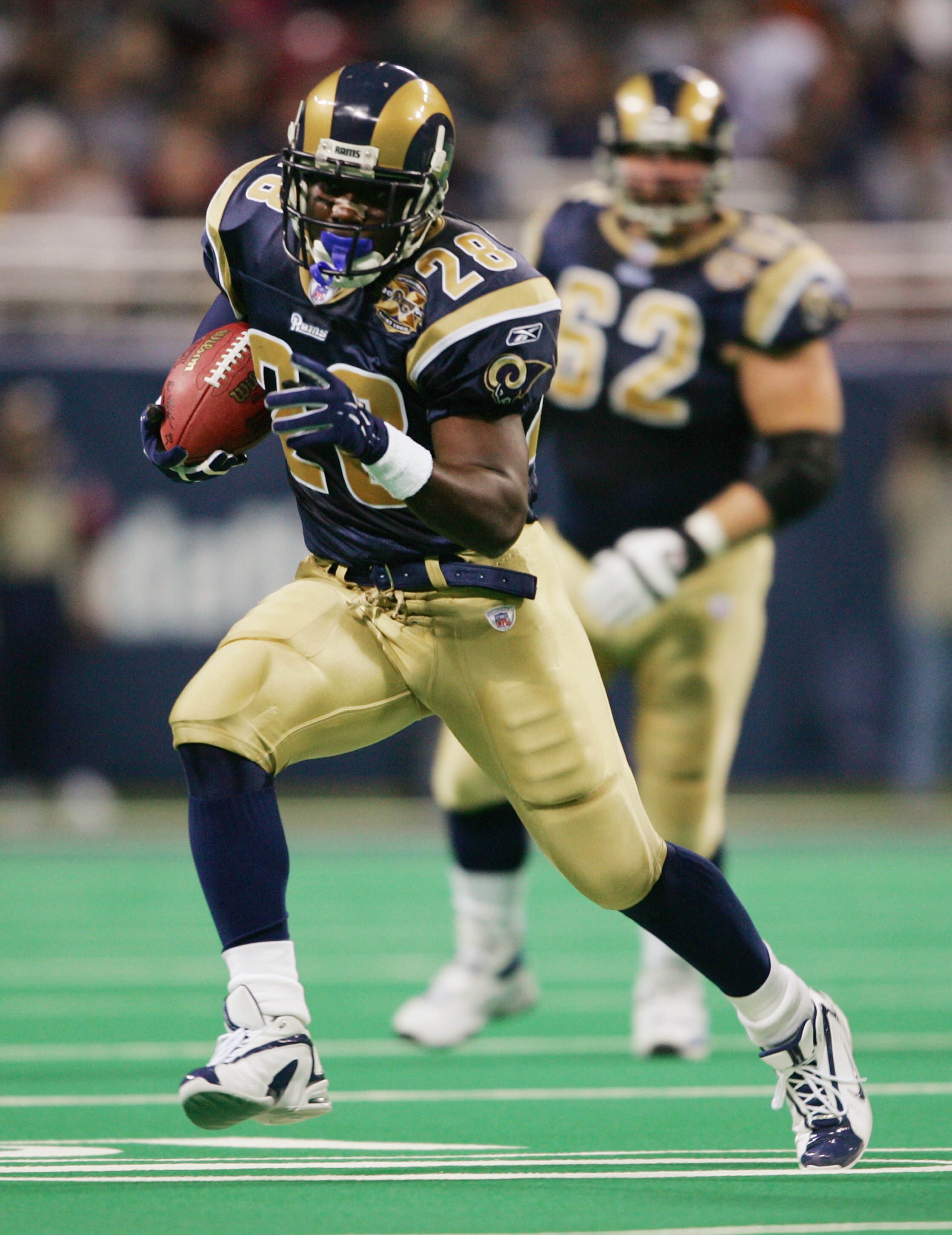ST. LOUIS - NOVEMBER 7:   Running back Marshall Faulk #28 of the St. Louis Rams runs upfield against the New England Patriots on November 7, 2004 at the Edward Jones Dome in St. Louis, Missouri. The Patriots defeated the Rams 40-22. (Photo by Elsa/Getty I