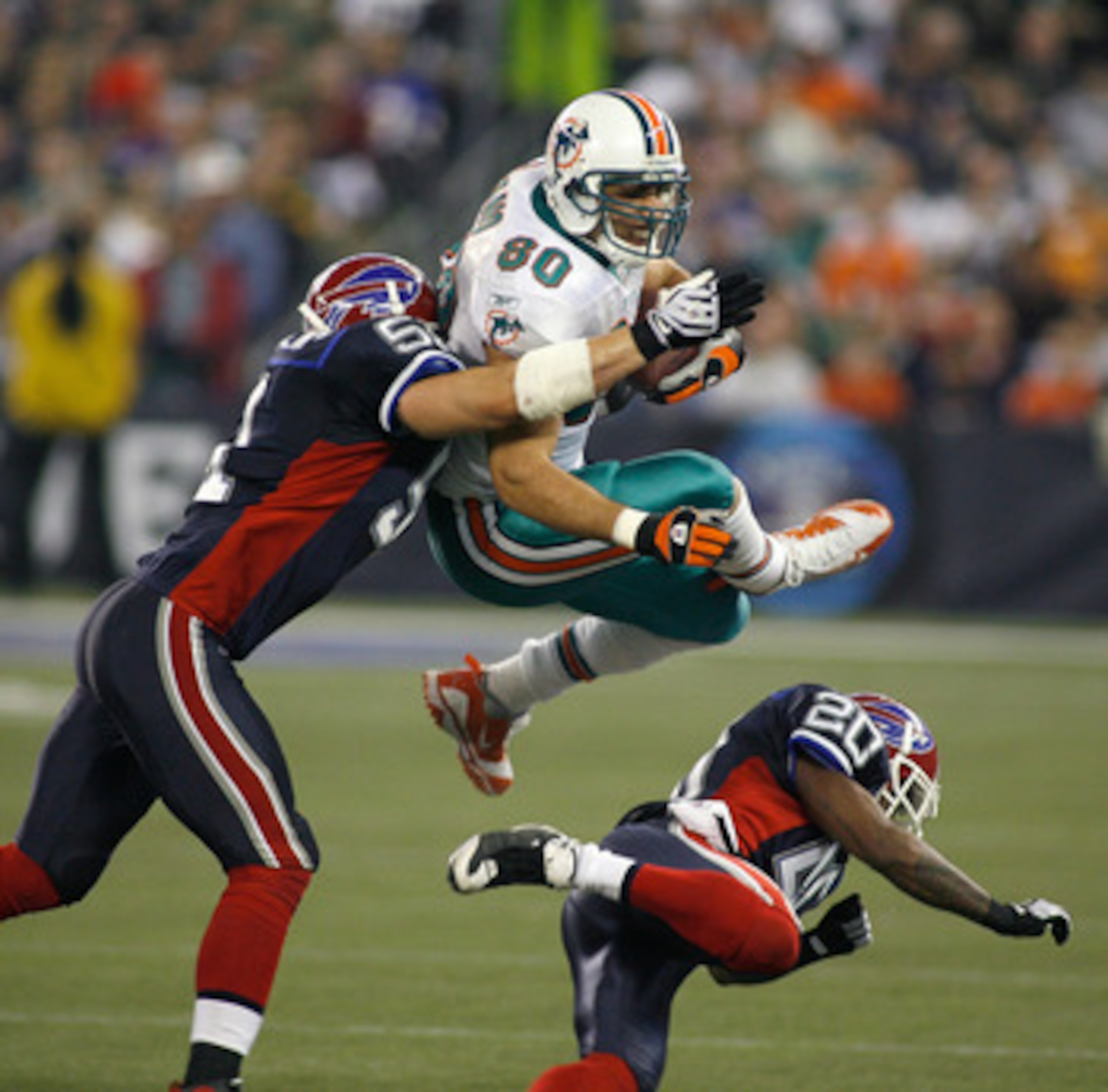 TORONTO, ON - DECEMBER 07: Anthony Fasano #80 of the Miami Dolphins is stopped by Paul Posluzny #51 and Donte Whitner #20 of the Buffalo Bills on December 7, 2008  at Rogers Centre in Toronto, Ontario, Canada. The Dolphins won 16-3. (Photo by Rick Stewart