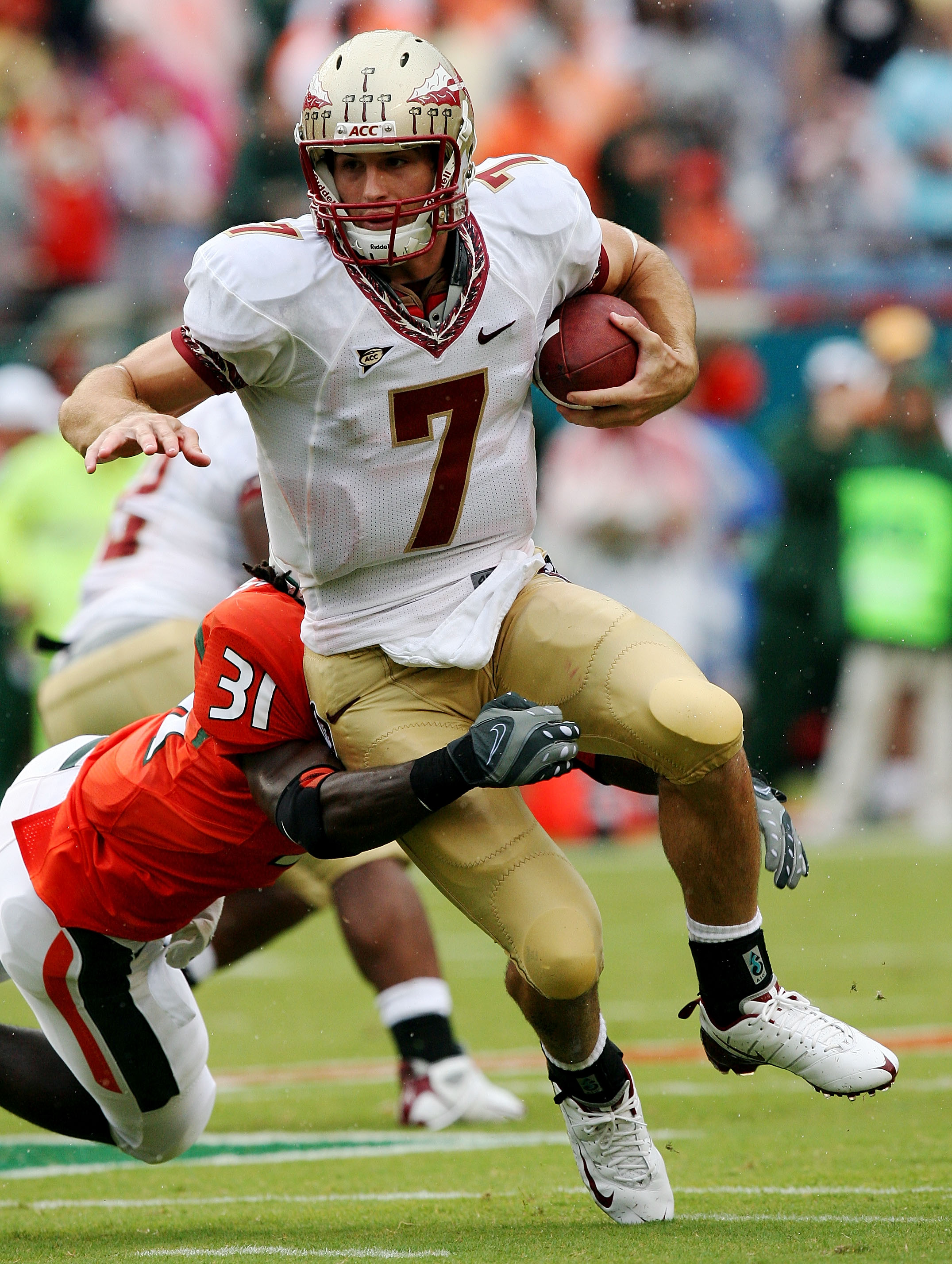 MIAMI - OCTOBER 04:  Quarterback Christian Ponder #7 of the Florida State Seminoles breaks a tackle attempt by linebacker Sean Spence #31 of the Miami Hurricanes at Dolphin Stadium on October 4, 2008 in Miami, Florida.  (Photo by Doug Benc/Getty Images)