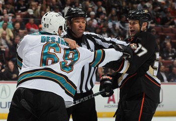 ANAHEIM, CA - APRIL 06:  Linesman Jay Sharrers seperates Andrew Desjardins #69 of the San Jose Sharks and Jarkko Ruutu #37 of the Anaheim Ducks in the second period at Honda Center on April 6, 2011 in Anaheim, California. The Ducks defeated the Sharks 6-2