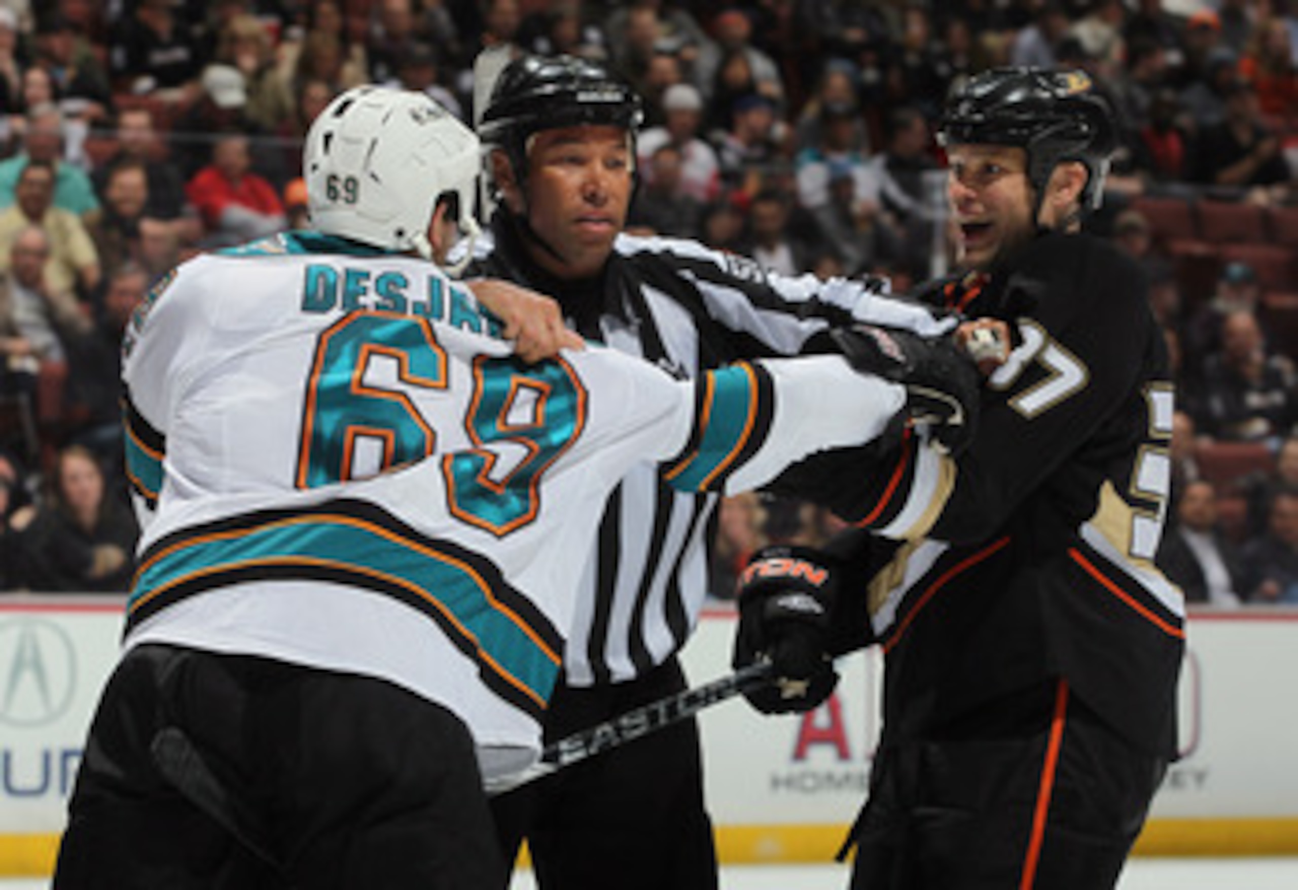 ANAHEIM, CA - APRIL 06:  Linesman Jay Sharrers seperates Andrew Desjardins #69 of the San Jose Sharks and Jarkko Ruutu #37 of the Anaheim Ducks in the second period at Honda Center on April 6, 2011 in Anaheim, California. The Ducks defeated the Sharks 6-2
