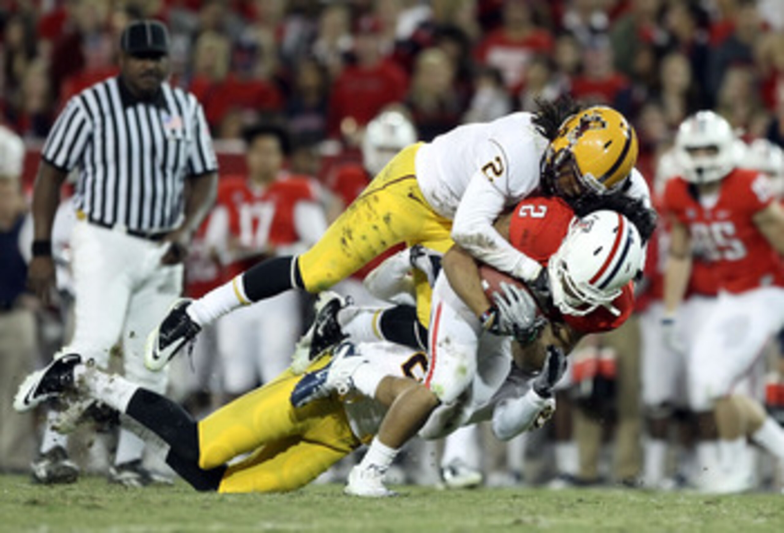 TUCSON, AZ - DECEMBER 02:  Runningback Keola Antolin #2 of the Arizona Wildcats rushes the football against Eddie Elder #2 of the Arizona State Sun Devils during the college football game at Arizona Stadium on December 2, 2010 in Tucson, Arizona.  (Photo