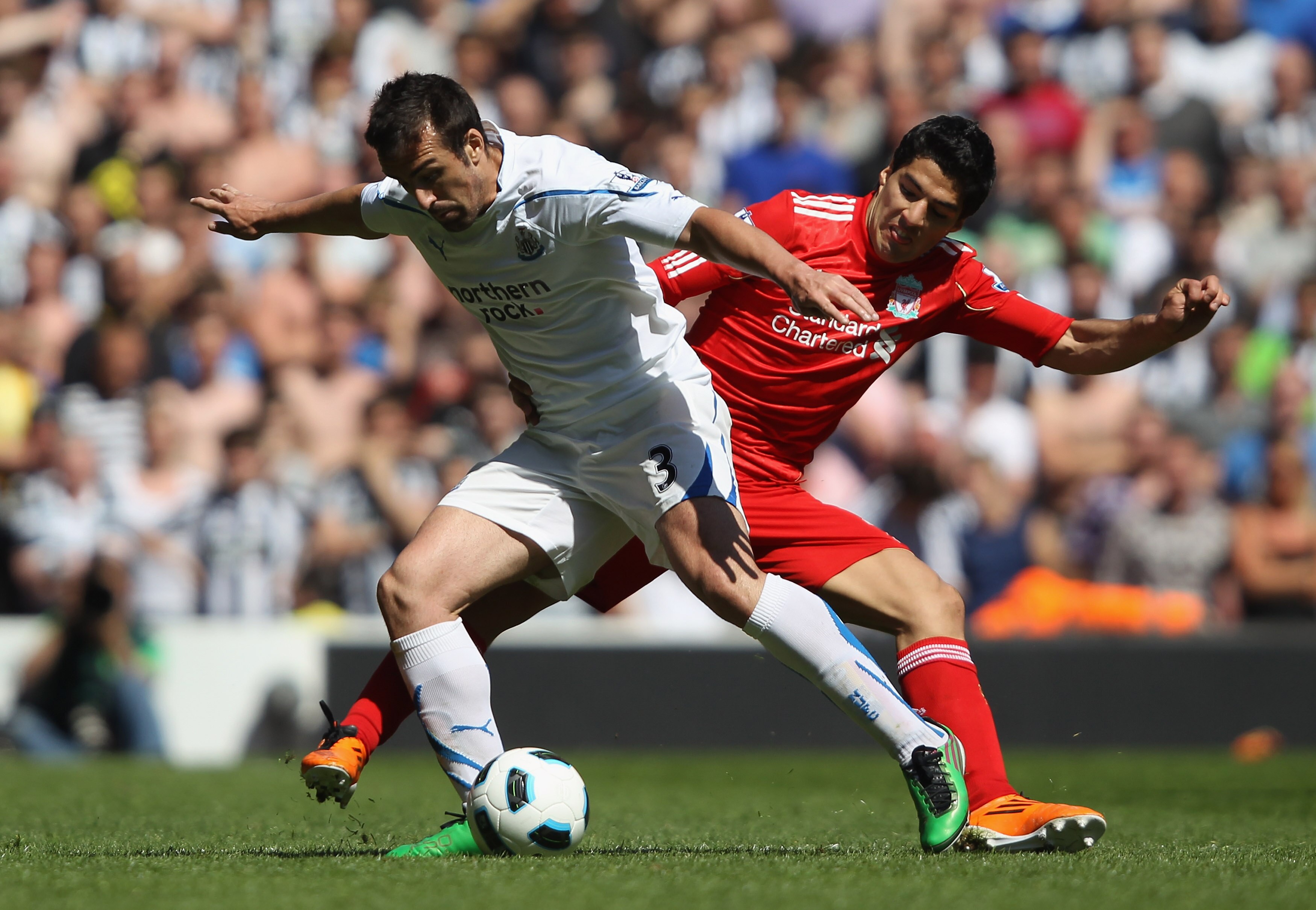 LIVERPOOL, ENGLAND - MAY 01: Jose Enrique of Newcastle United holds off  Luis Suarez of Liverpool during the Barclays Premier League match between Liverpool  and Newcastle United at Anfield on May 1, 2011 in Liverpool, England.  (Photo by Clive Brunskill/