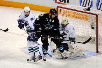 SAN JOSE, CA - MAY 22:   Joe Thornton #19 of the San Jose Sharks screens goaltender Roberto Luongo #1 of the Vancouver Canucks as Dan Hamhuis #2 of the Vancouver Canucks defends the play in the first period in Game Four of the Western Conference Finals du