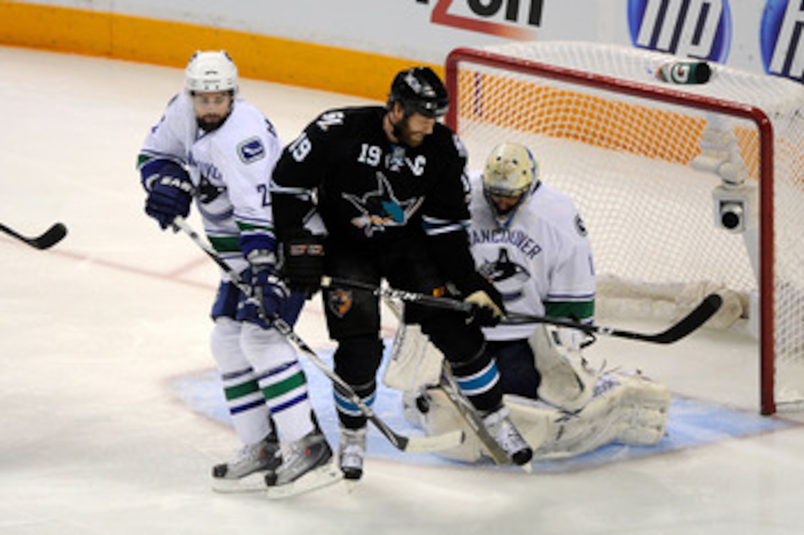 SAN JOSE, CA - MAY 22:   Joe Thornton #19 of the San Jose Sharks screens goaltender Roberto Luongo #1 of the Vancouver Canucks as Dan Hamhuis #2 of the Vancouver Canucks defends the play in the first period in Game Four of the Western Conference Finals du