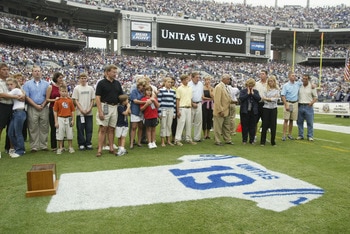BALTIMORE - SEPTEMBER  15:  Family and friends pay tribute to Johnny Unitas as they stand behind a jersey painted with his name and uniform number on the grass prior to the game between the Tampa Bay Buccaneers and the Baltimore Ravens on September 15, 20