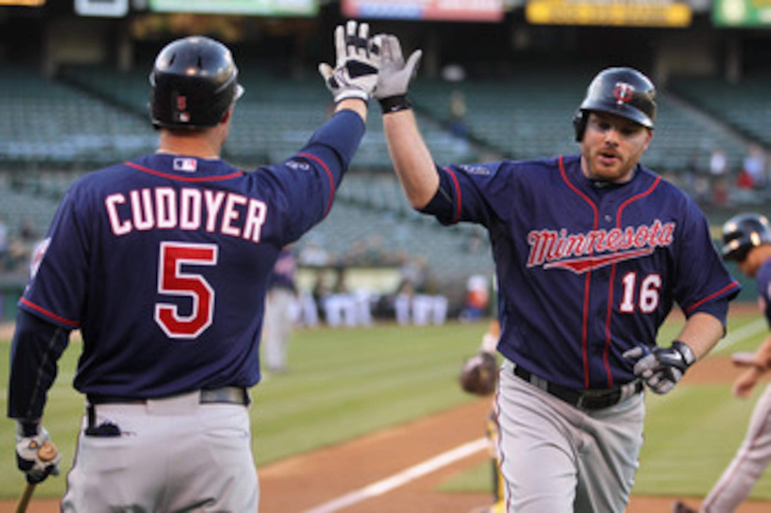 OAKLAND, CA - MAY 18:  Jason Kubel #16 is congratulated by Michael Cuddyer #5 of the Minnesota Twins after he scored in the first inning against the Oakland Athletics at Oakland-Alameda County Coliseum on May 18, 2011 in Oakland, California.  (Photo by Ez