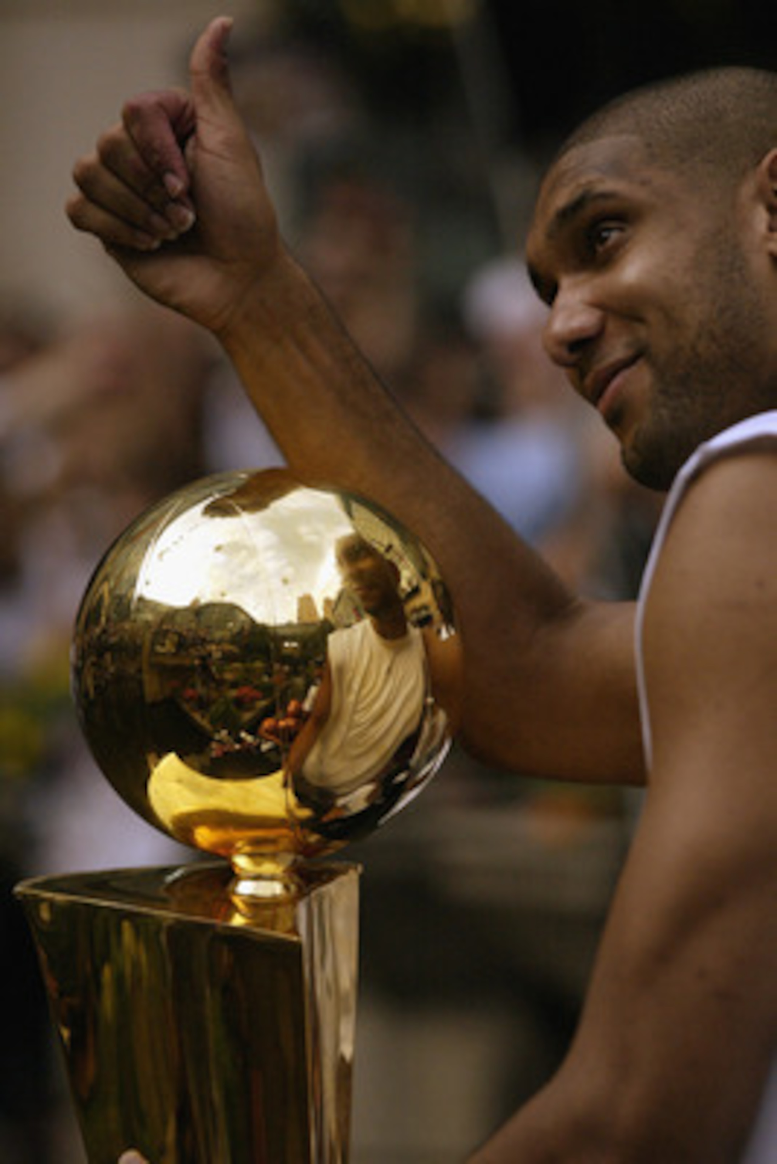 SAN ANTONIO - JUNE 18:  Tim Duncan #21 of the San Antonio Spurs celebrates with the 2003 NBA Championship trophy during the SBC 2003 Spurs Championship Celebration on June 18, 2003 at the Riverwalk in San Antonio, Texas.  NOTE TO USER: User expressly ackn