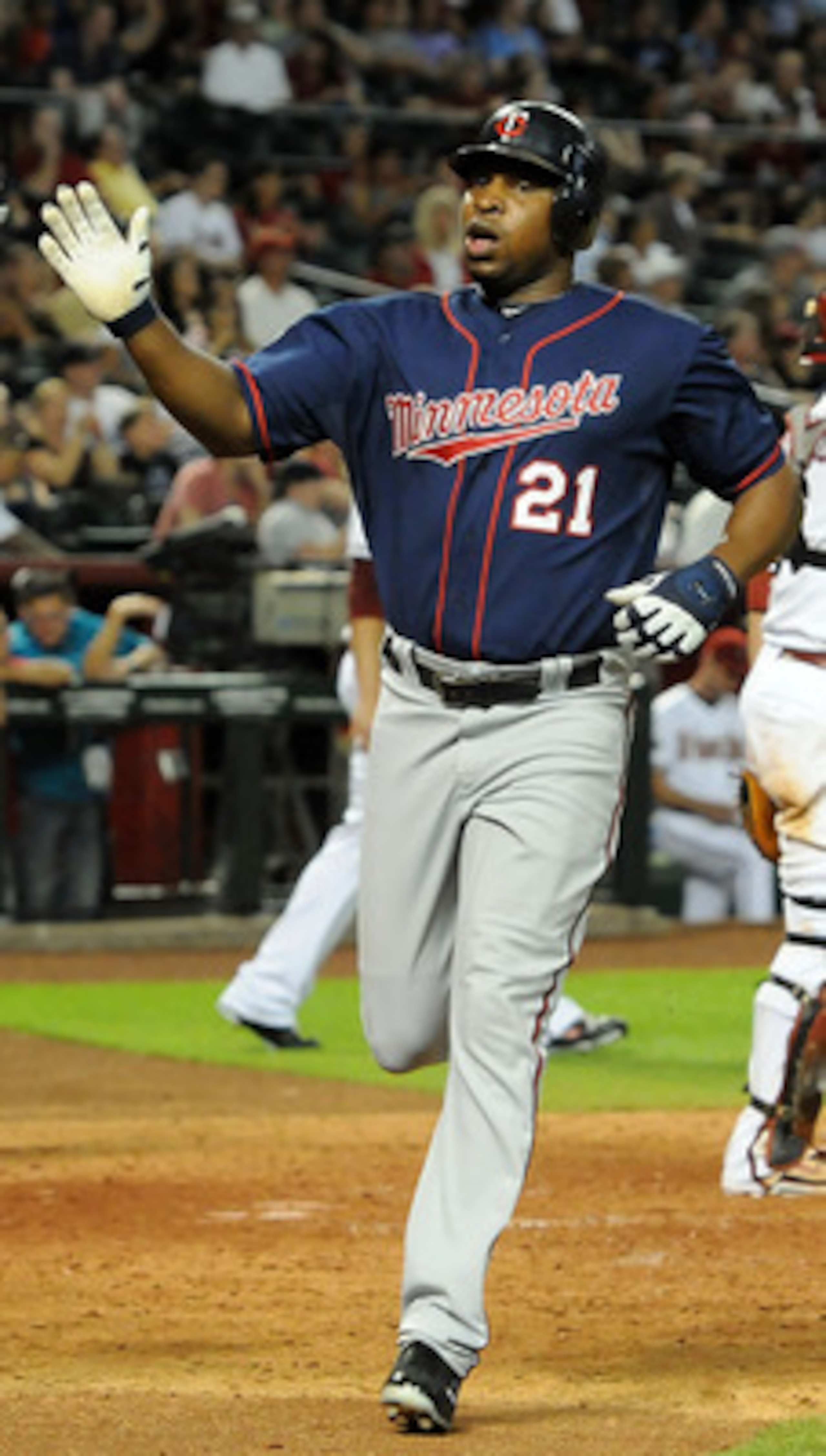 PHOENIX - MAY 20:  Delmon Young #21 of the Minnesota Twins gets a high-five from teammate Matt Tolbert #20 after scoring against the Arizona Diamondbacks at Chase Field on May 20, 2011 in Phoenix, Arizona.  (Photo by Norm Hall/Getty Images)