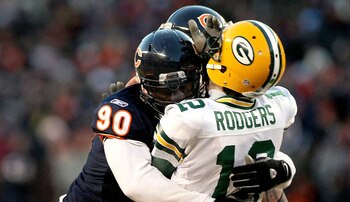 CHICAGO, IL - JANUARY 23:  Quarterback Aaron Rodgers #12 of the Green Bay Packers is hit by Julius Peppers #90 of the Chicago Bears in the helmet as Peppers was called for a personal foul in the fourth quarter of the NFC Championship Game at Soldier Field