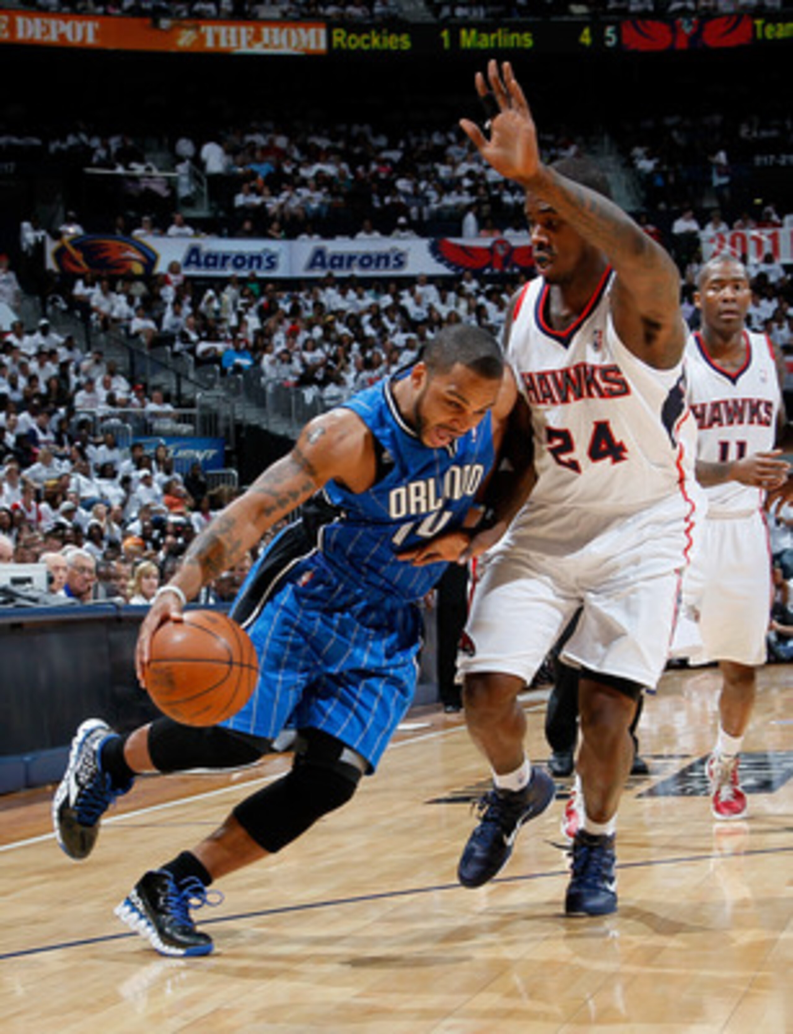 ATLANTA, GA - APRIL 22:  Jameer Nelson #14 of the Orlando Magic draws a foul from Marvin Williams #24 of the Atlanta Hawks during Game Three of the Eastern Conference Quarterfinals in the 2011 NBA Playoffs at Philips Arena on April 22, 2011 in Atlanta, Ge