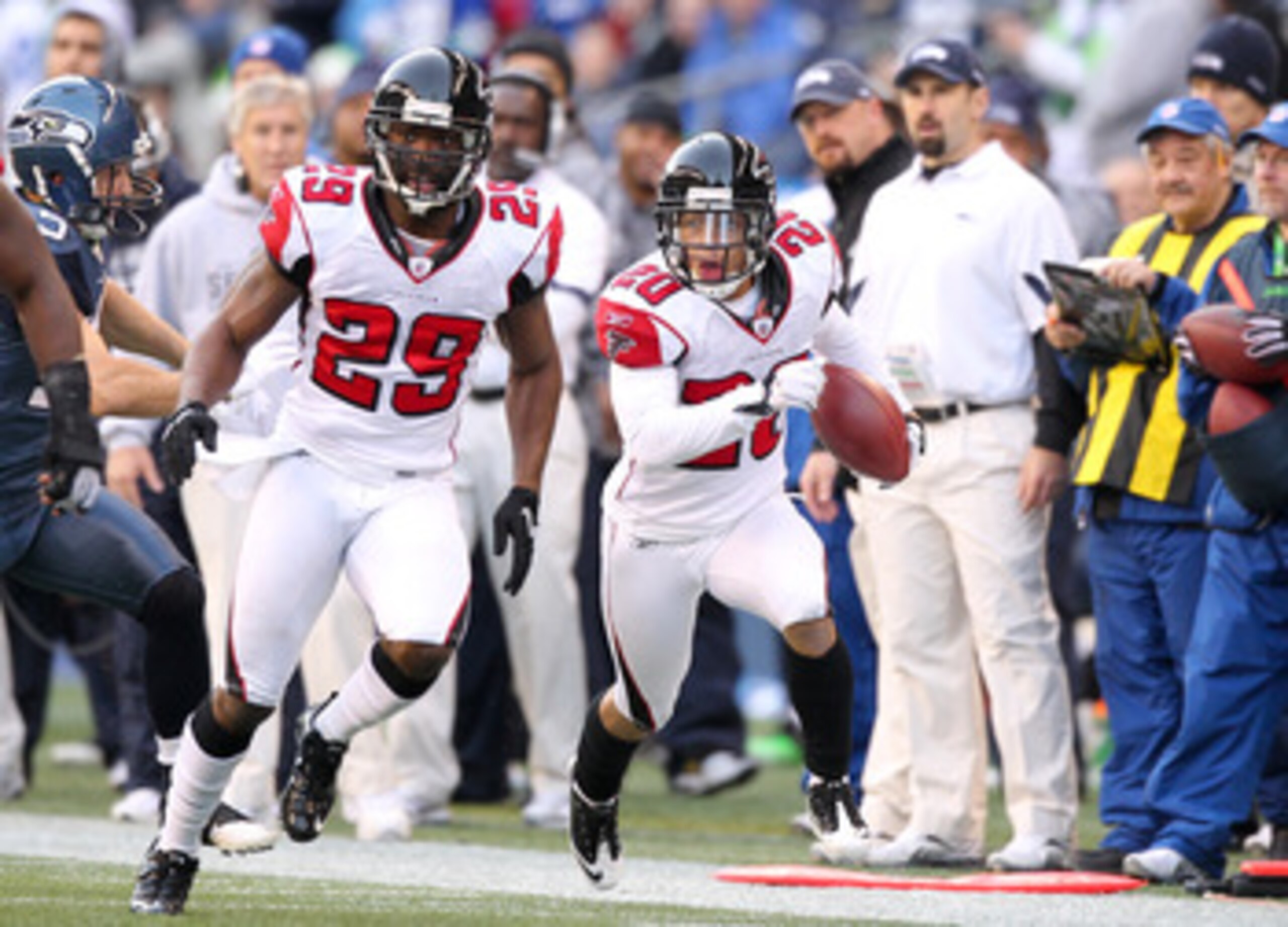 SEATTLE, WA - DECEMBER 19:  Brent Grimes #20 of the Atlanta Falcons returns an interception as Brian Williams #29 leads the block against the Seattle Seahawks at Qwest Field on December 19, 2010 in Seattle, Washington. The Falcons defeated the Seahawks 34