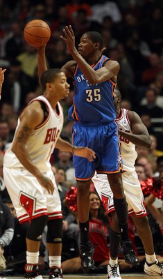 CHICAGO - JANUARY 04: Kevin Durant #35 of the Oklahoma City Thunder passes the ball between Derrick Rose #1 and Loul Deng #9 of the Chicago Bulls at the United Center on January 4, 2010 in Chicago, Illinois. The Thunder defeated the Bulls 98-85. NOTE TO U