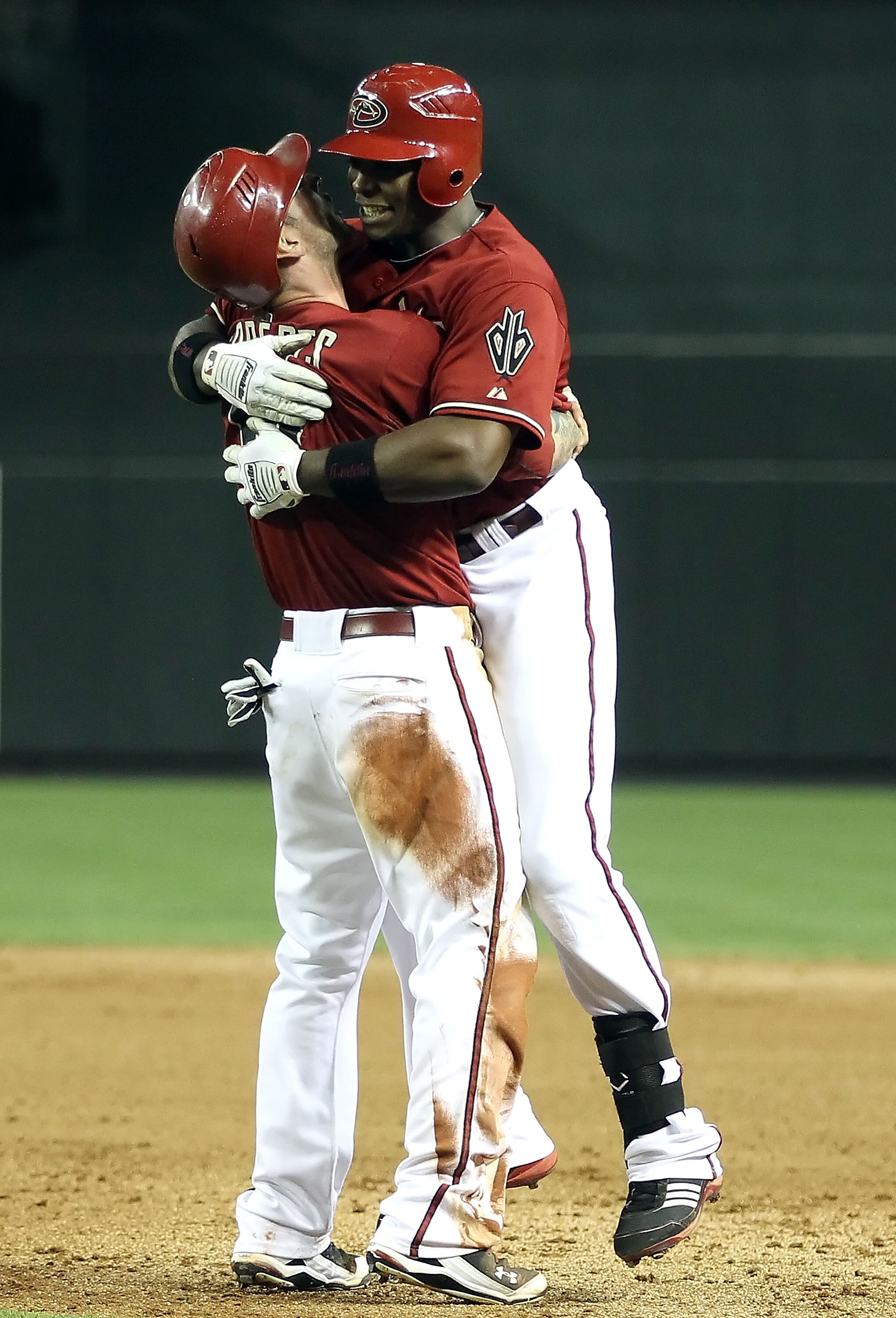 PHOENIX, AZ - MAY 18:  Justin Upton #10 and Ryan Roberts #14 of the Arizona Diamondbacks celebrate after Upton had the game winning RBI single against the Atlanta Braves in the eleventh inning of the Major League Baseball game at Chase Field on May 18, 20