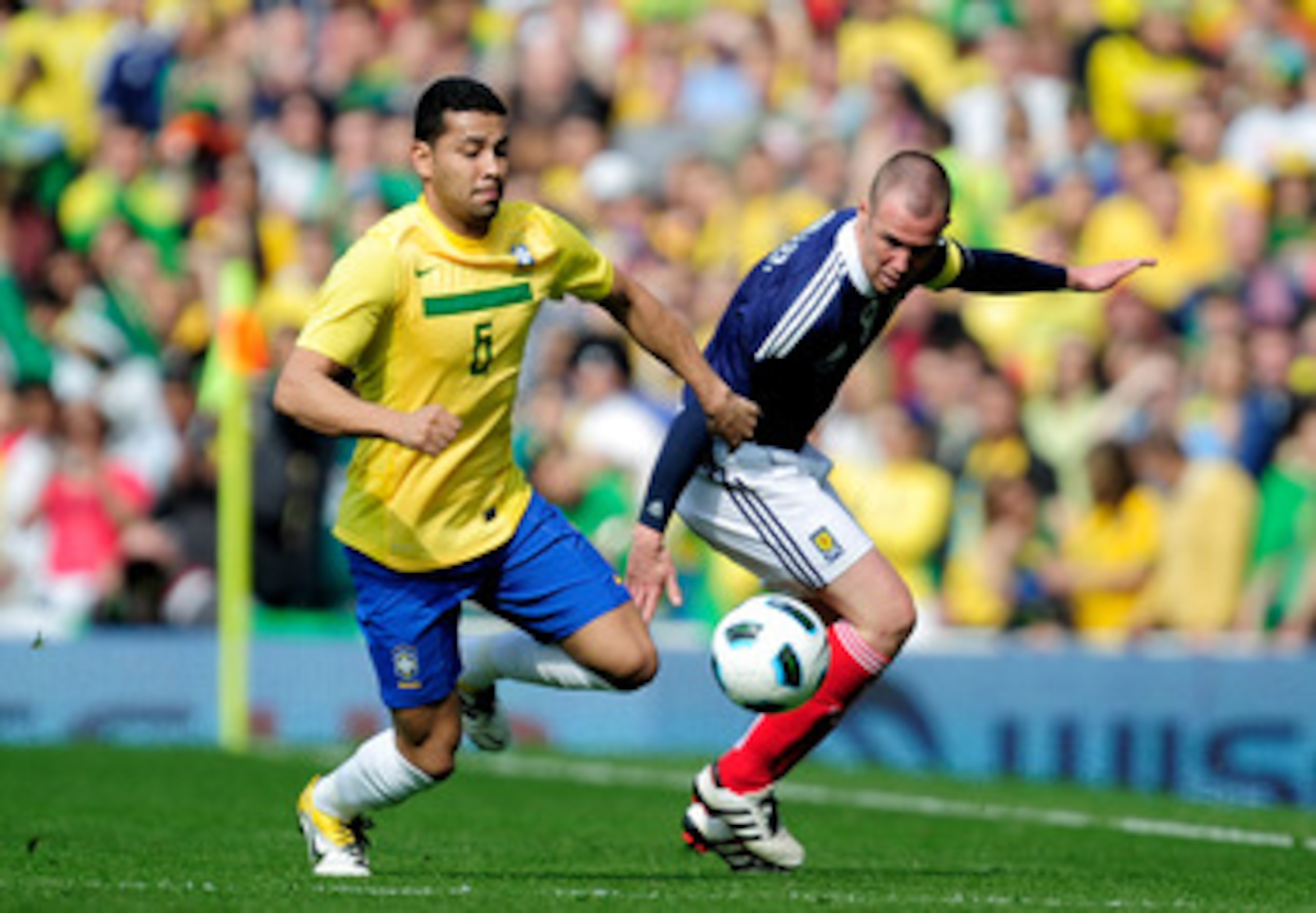 LONDON, ENGLAND - MARCH 27:  Andre Santos of Brazil fights for the ball with Kenny Miller of Scotland during the International friendly match between Brazil and Scotland at Emirates Stadium on March 27, 2011 in London, England.  (Photo by Jamie McDonald/G