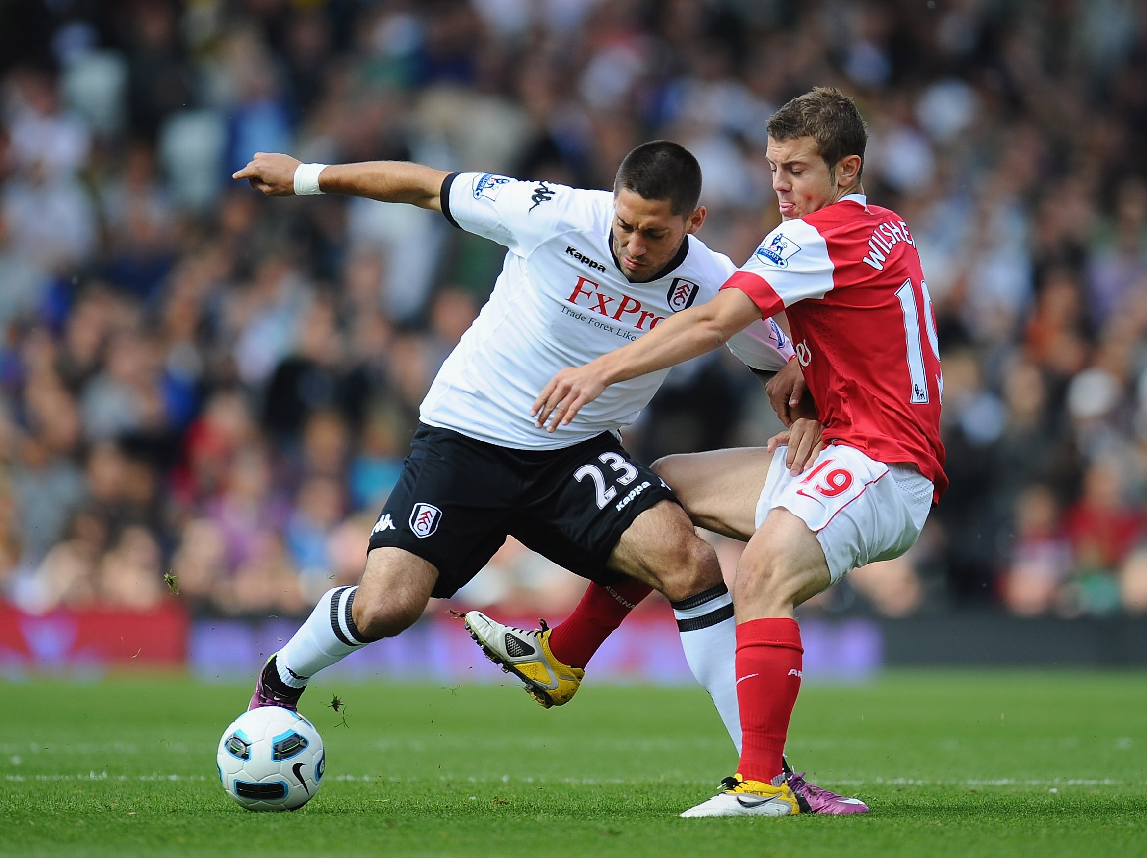 LONDON, ENGLAND - MAY 22:  Clint Dempsey of Fulham holds off a challenge from Jack Wilshere of Arsenal during the Barclays Premier League match between Fulham and Arsenal at Craven Cottage on May 22, 2011 in London, England.  (Photo by Clive Mason/Getty I