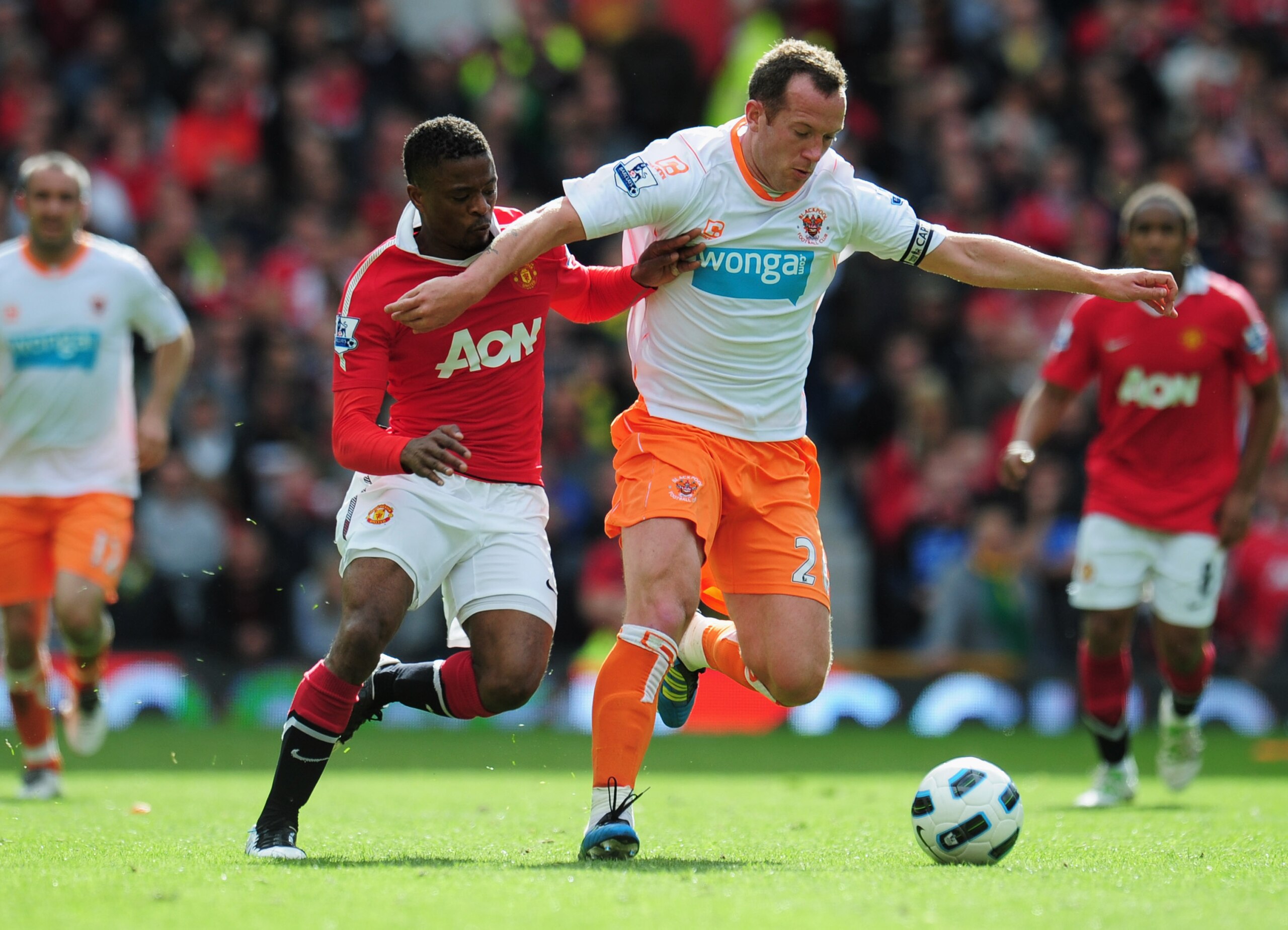MANCHESTER, ENGLAND - MAY 22:  Charlie Adam of Balckpool battles with Patrice Evra of Manchester United during the Barclays Premier League match between Manchester United and Blackpool at Old Trafford on May 22, 2011 in Manchester, England.  (Photo by Sha