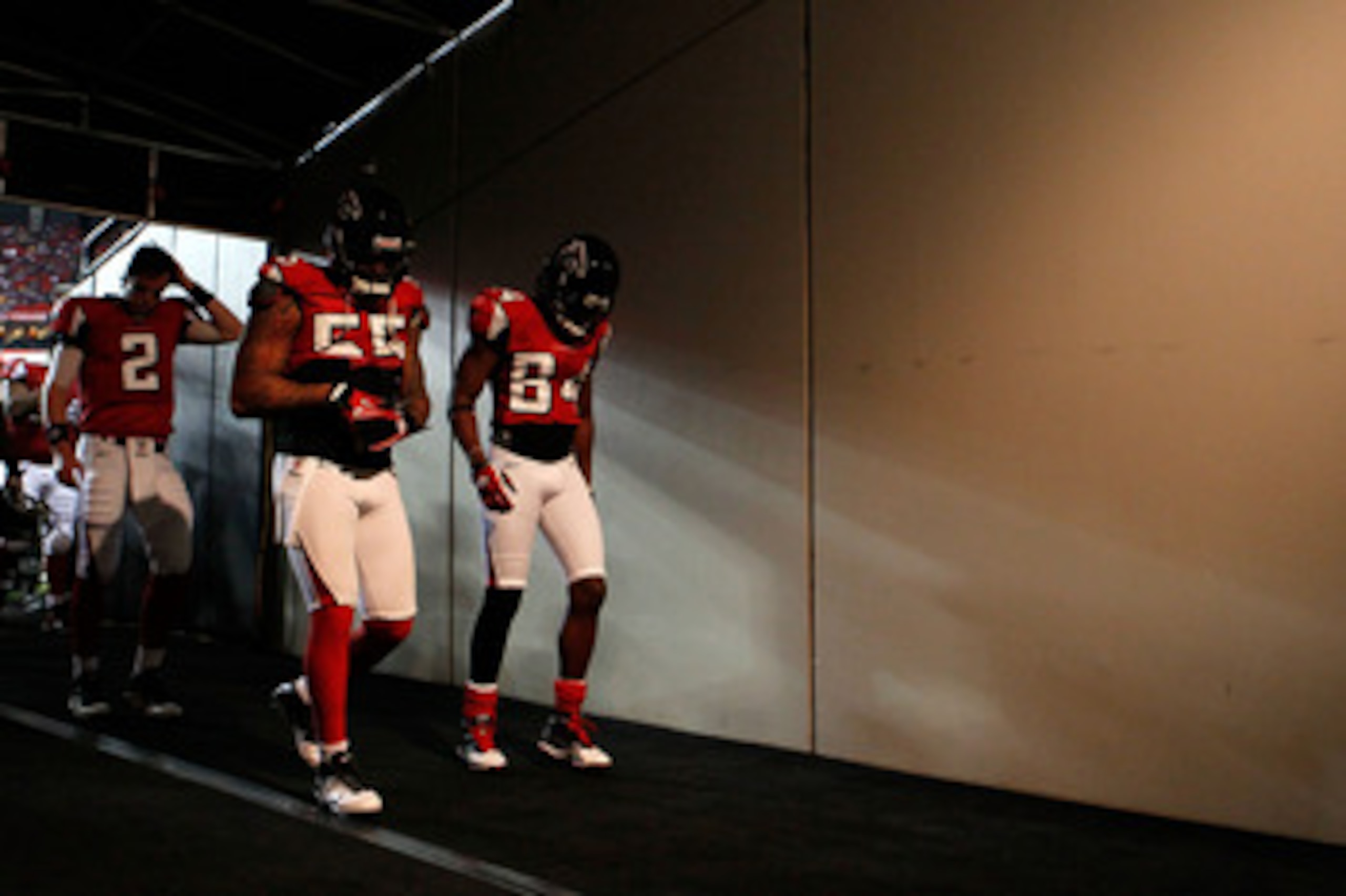ATLANTA, GA - JANUARY 15:  (L-R) Quarterback Matt Ryan #2, John Abraham #55 and Roddy White #84 of the Atlanta Falcons walk to the locker room from the field following warm ups against the Green Bay Packers during their 2011 NFC divisional playoff game at