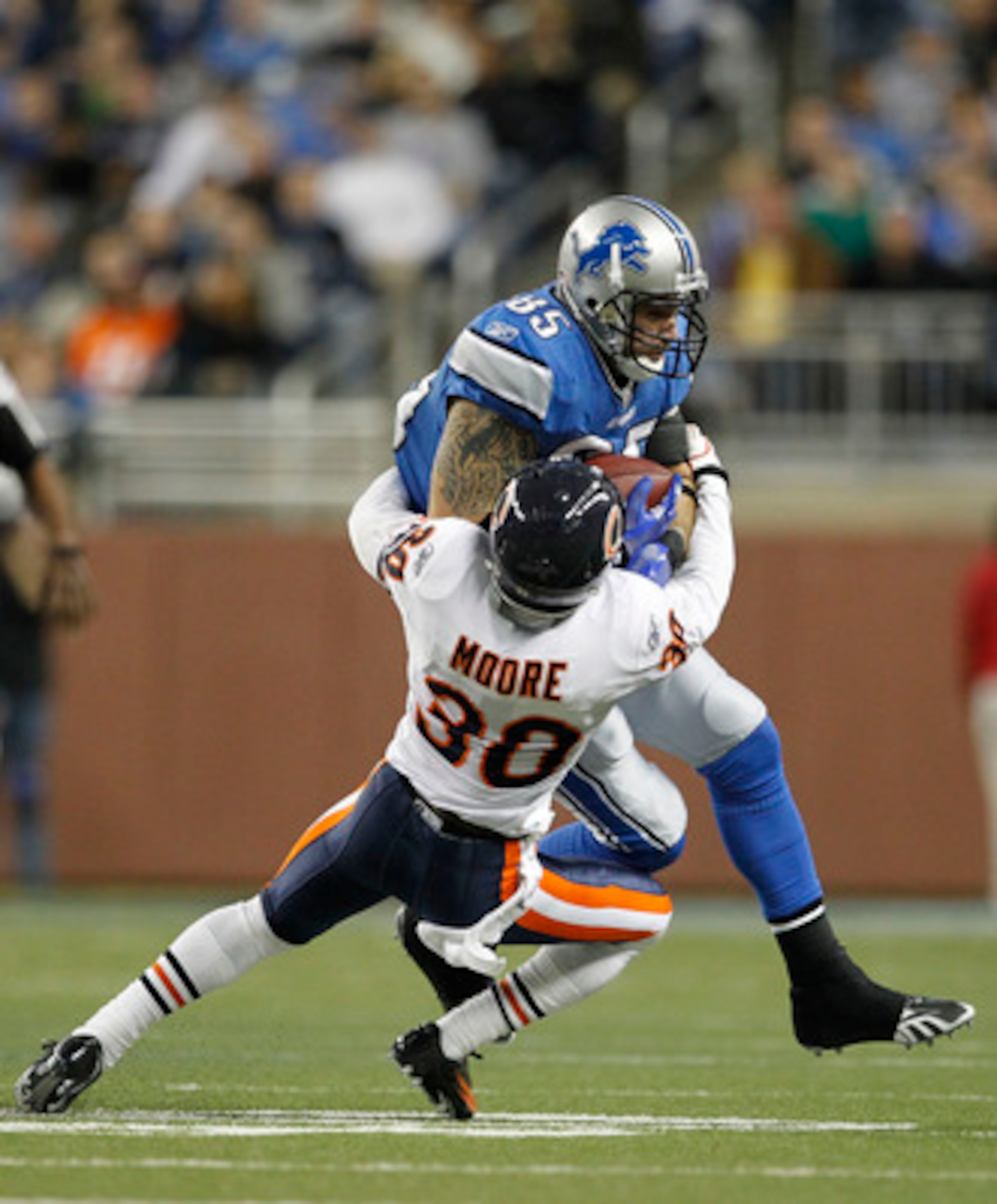 DETROIT - DECEMBER 05: D. J. Moore #30 of the Chicago Bears stops Tony Scheffler #85 of the Detroit Lions during the fourth quarter of the game at Ford Field on December 5, 2010 in Detroit, Michigan. The Bears defeated the Lions 24-20. (Photo by Leon Hali