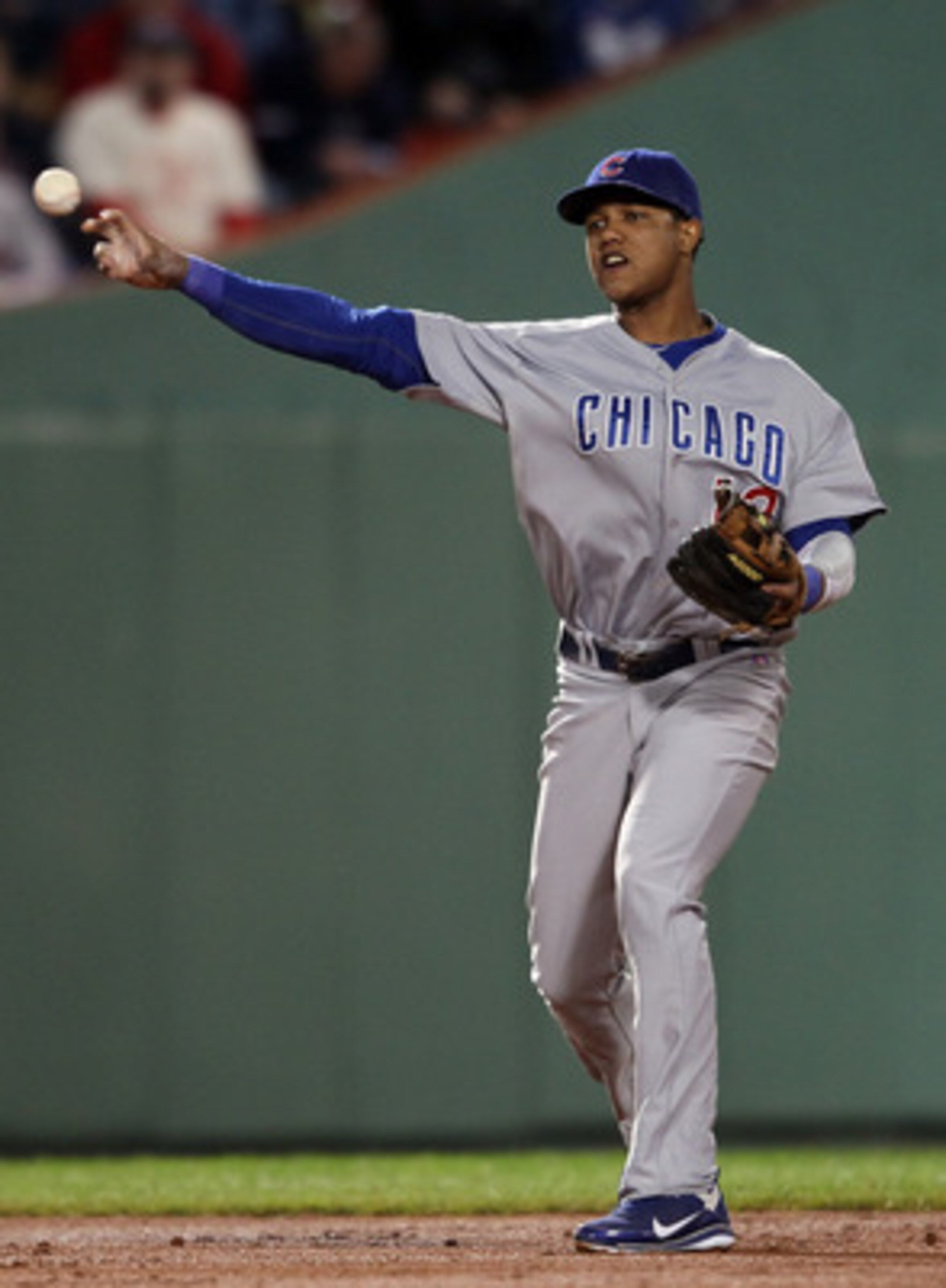 BOSTON, MA - MAY 22:  Starlin Castro #13 of the Chicago Cubs sends the ball for the out Dustin Pedroia of the Boston Red Sox at first base on May 22, 2011 at Fenway Park in Boston, Massachusetts.  Before this series, the two teams haven't played at Fenway