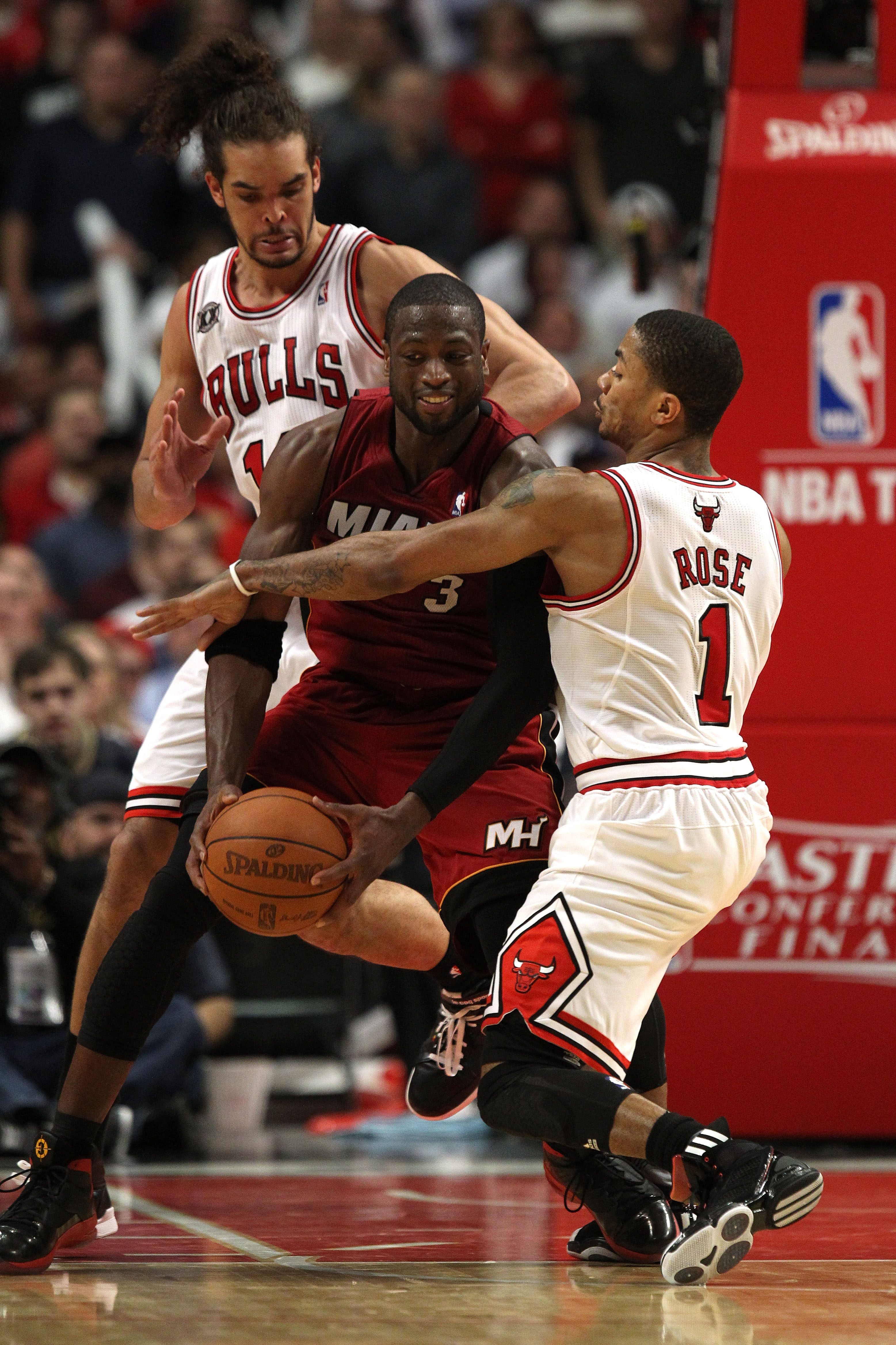 CHICAGO, IL - MAY 18:  Dwyane Wade #3 of the Miami Heat looks to pass as he is defended by Derrick Rose #1 and Joakim Noah #13 of the Chicago Bulls in Game Two of the Eastern Conference Finals during the 2011 NBA Playoffs on May 18, 2011 at the United Cen